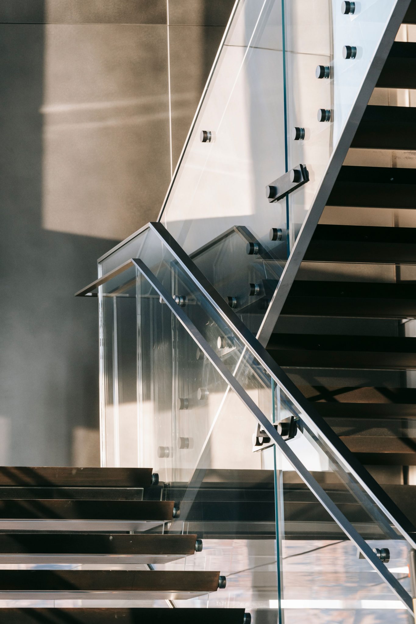 Interior of contemporary apartment with modern stairway with clean glass railings in daytime