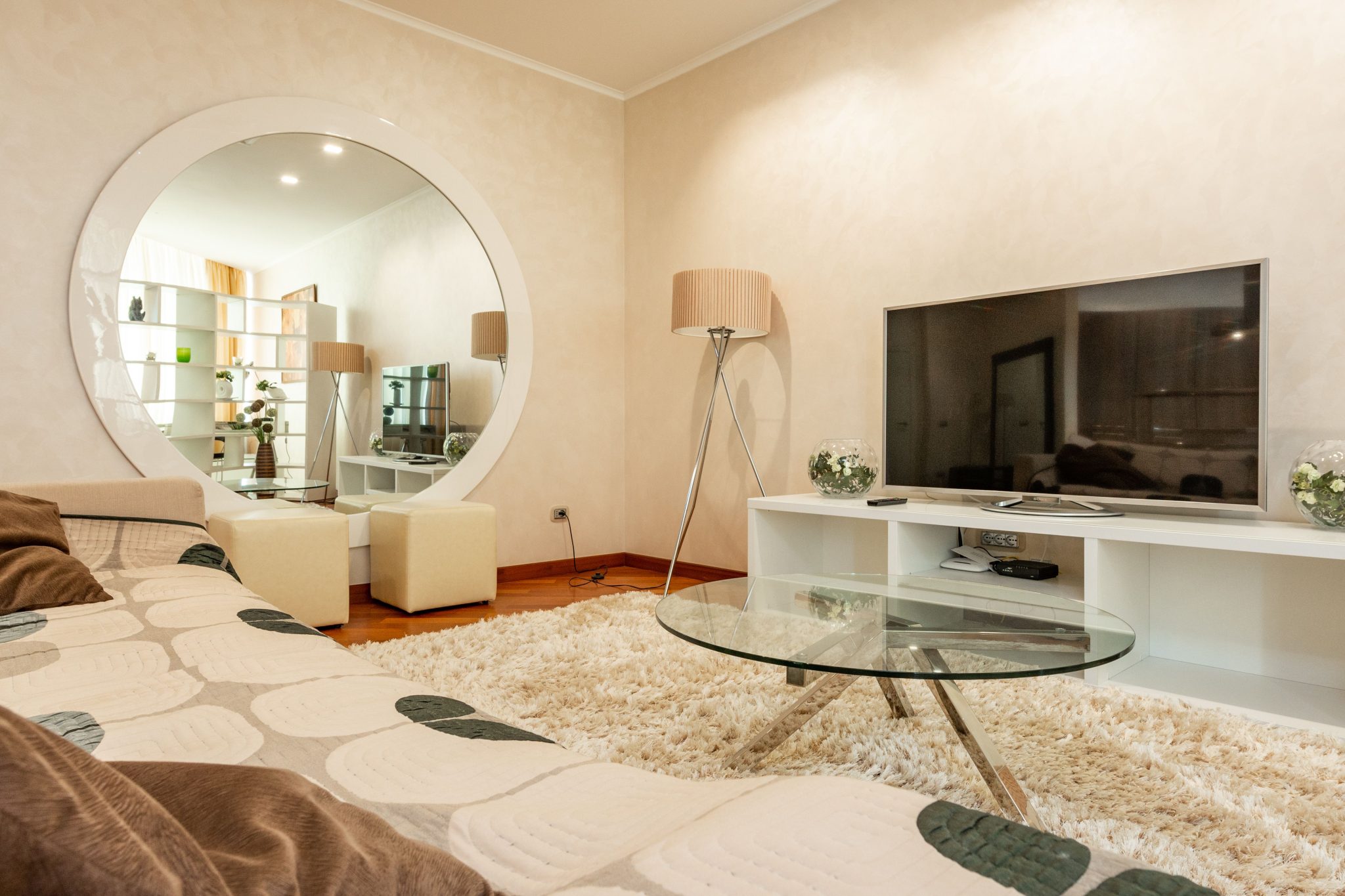 Interior of modern living room with round shaped mirror and couch with pattern