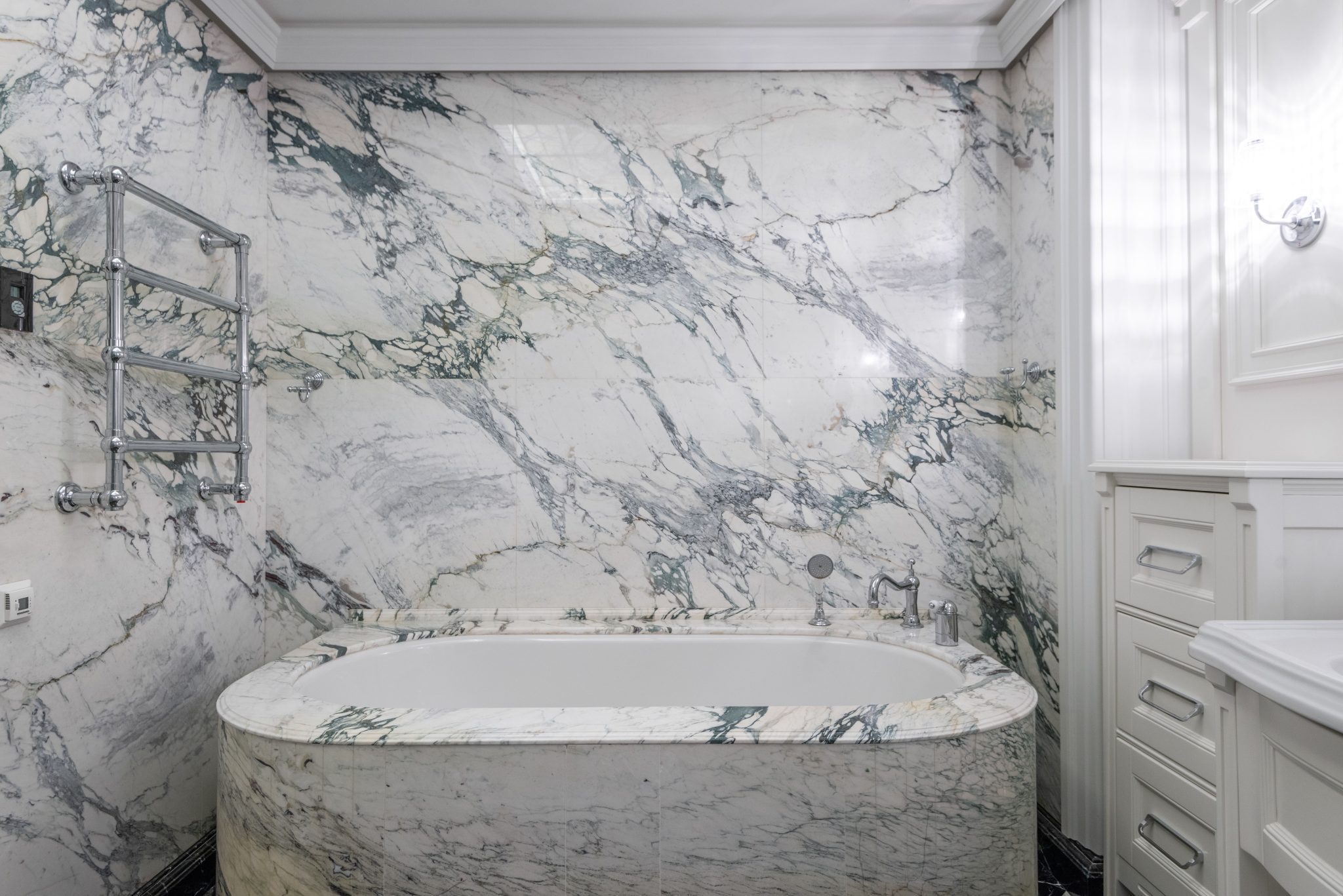 Luxurious modern bathroom with marble tub and wall, featuring elegant design elements.