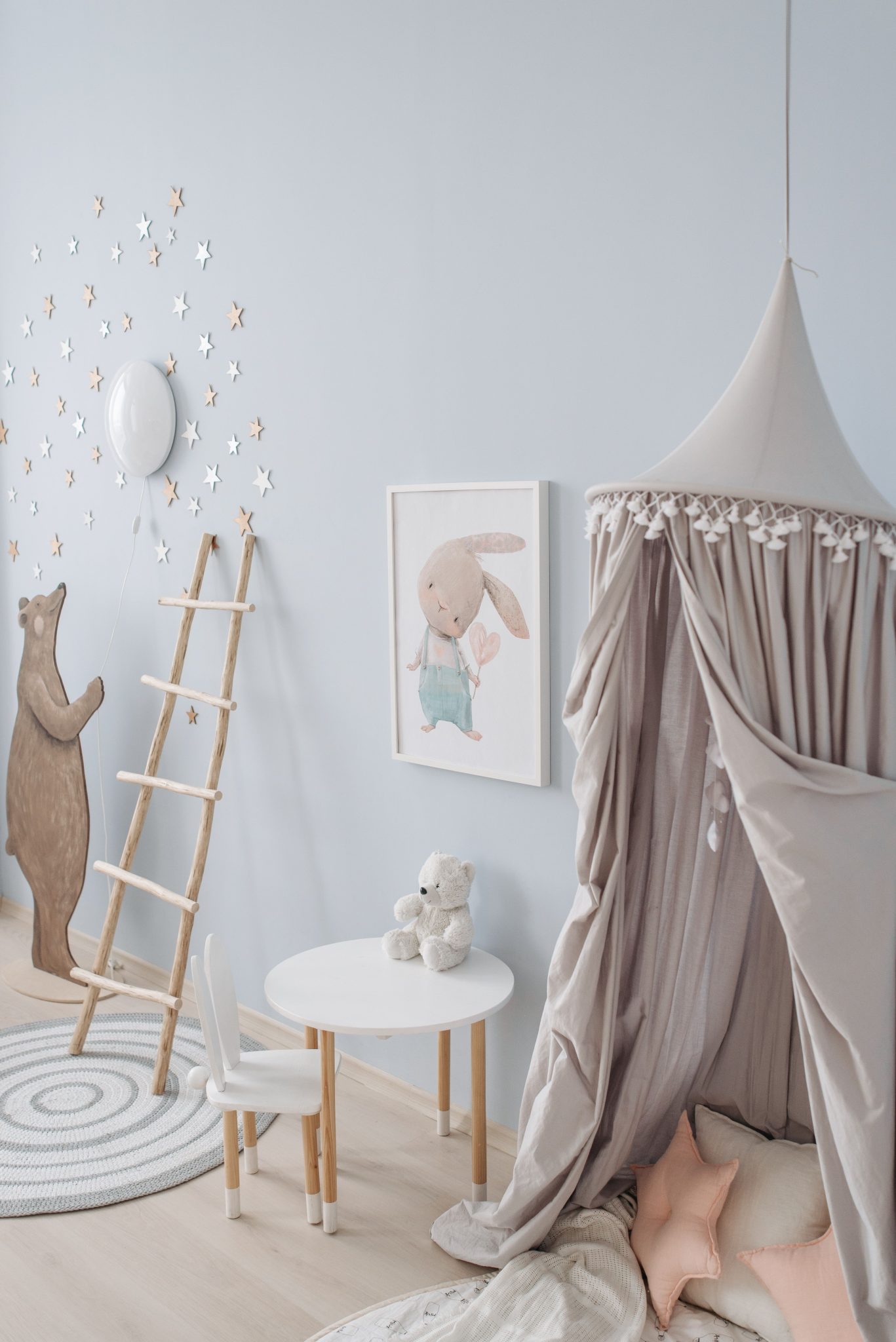 Minimalist children's room with canopy, wooden toys, and pastel decor.