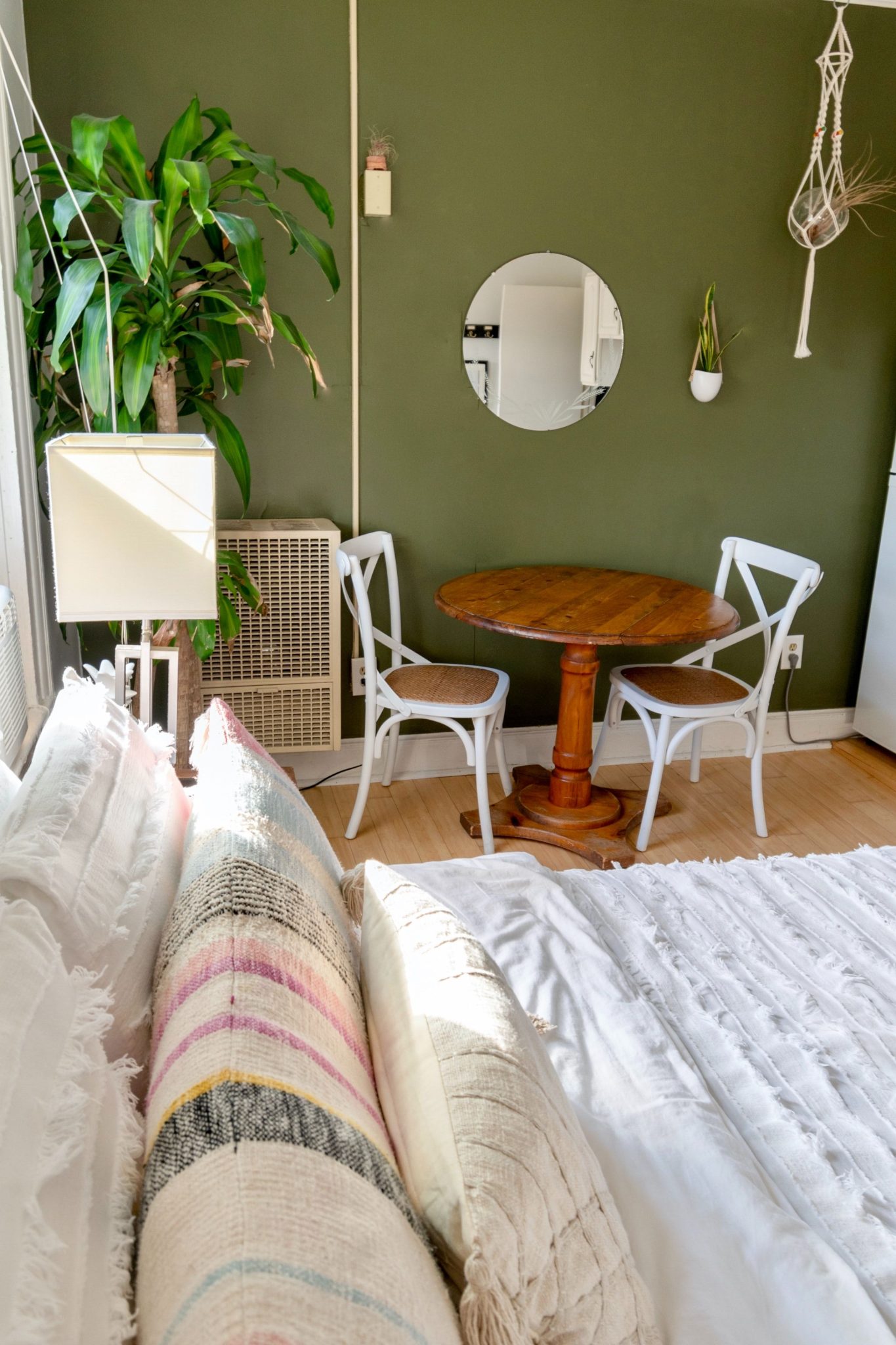 Modern bedroom in Burlington with green accent wall, rustic table, and indoor plants.
