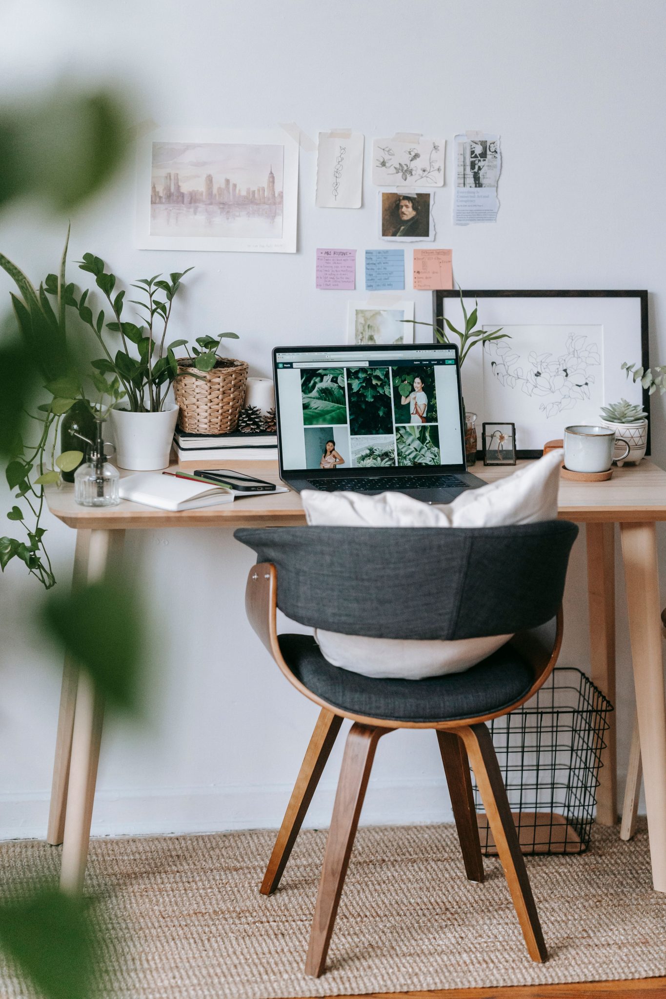 Modern workplace with table and green potted fresh plants near netbook in daylight
