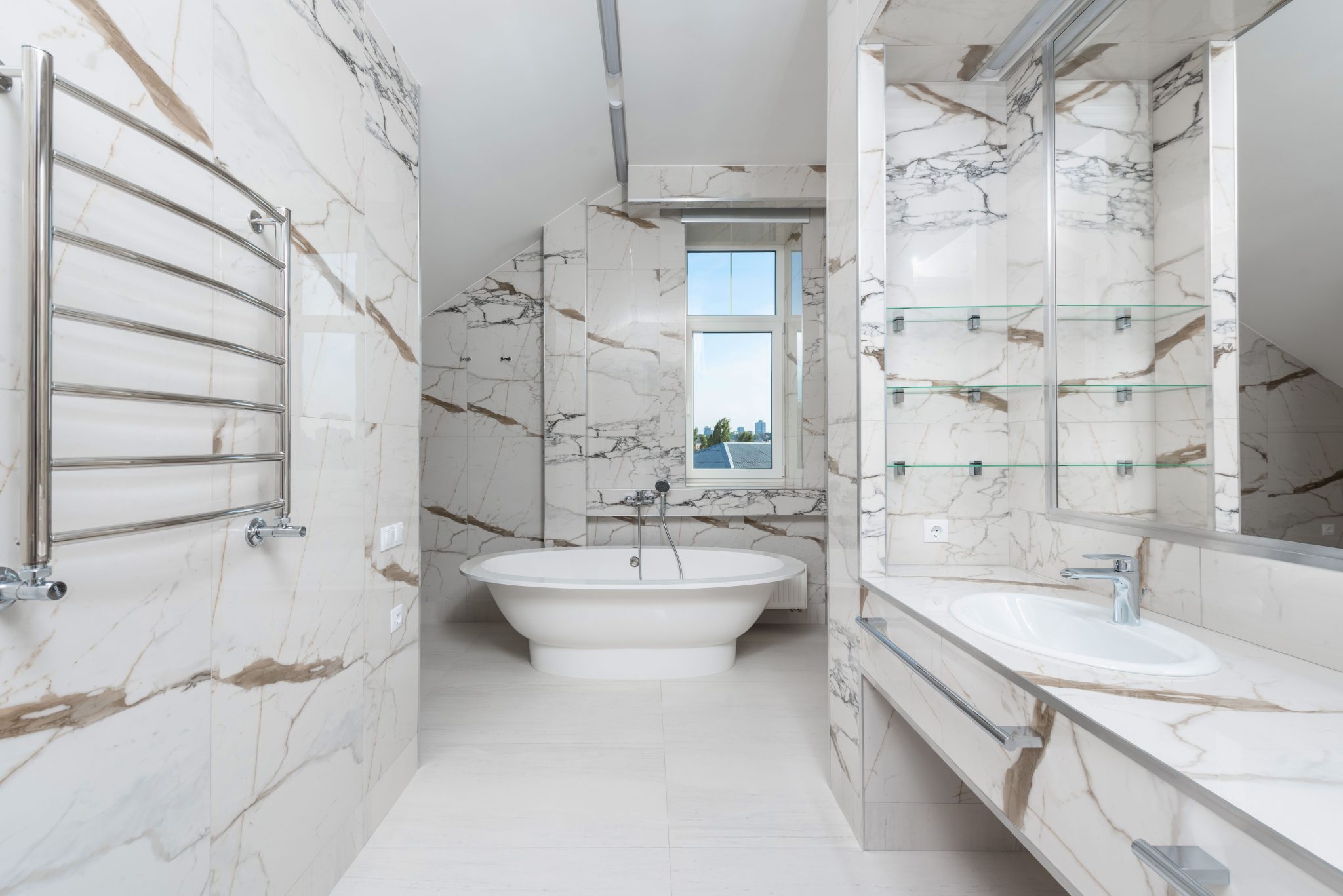 Spacious and elegant marble bathroom featuring a modern bathtub, sink, and glass window.