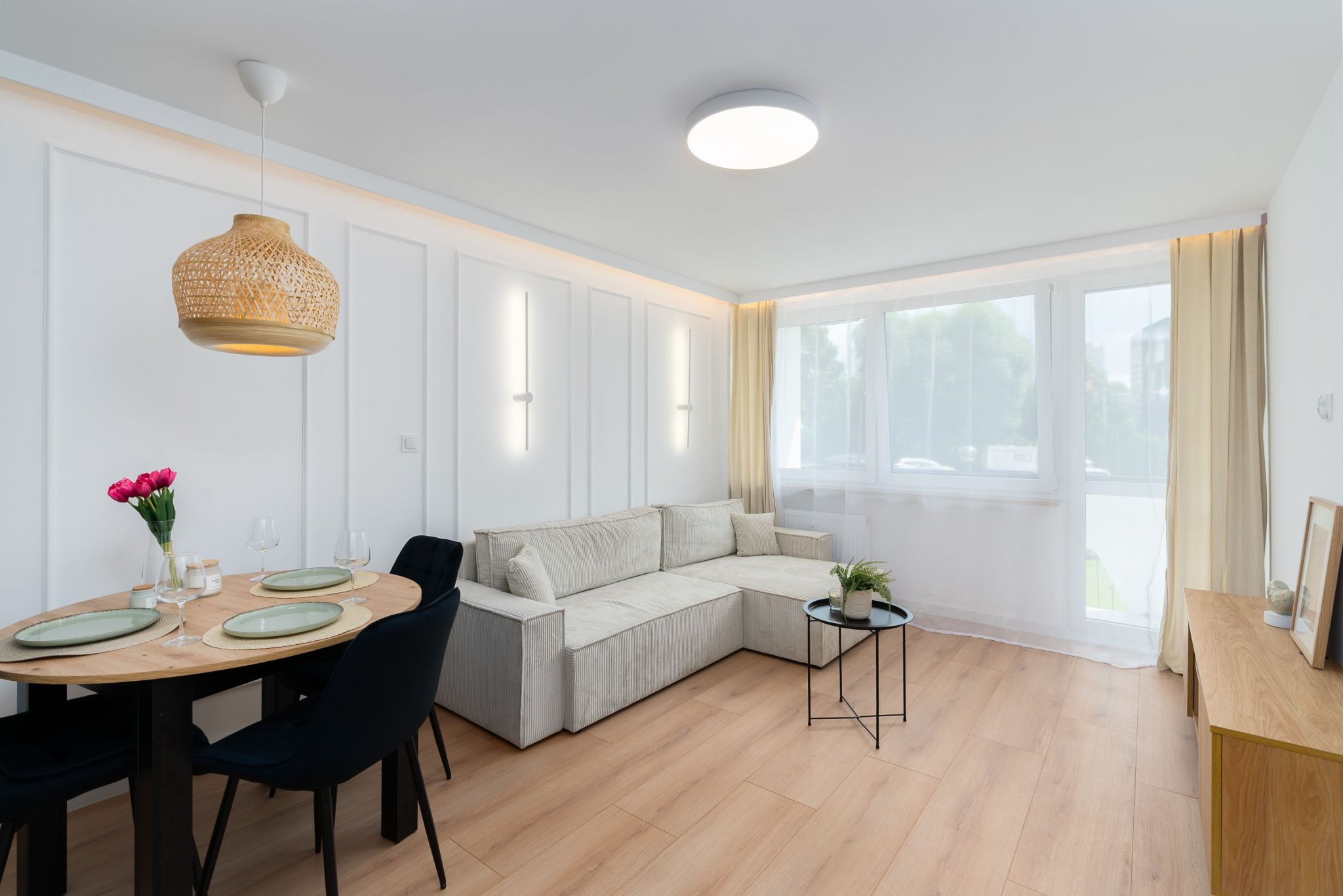 Spacious living room in Kraków with elegant minimalist decor and natural light.