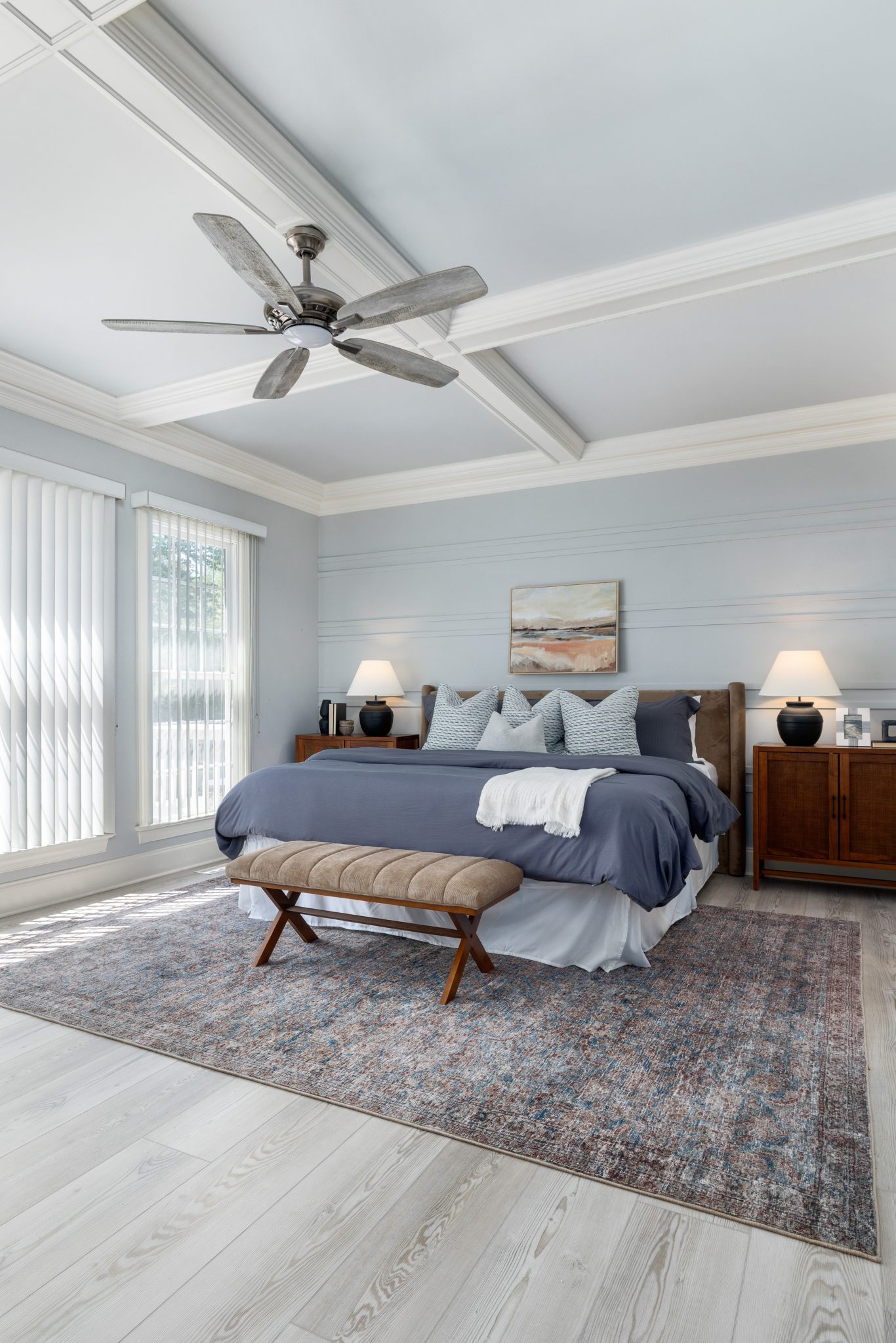 Spacious modern bedroom design featuring a blue color scheme, soft lighting, and elegant furnishings.