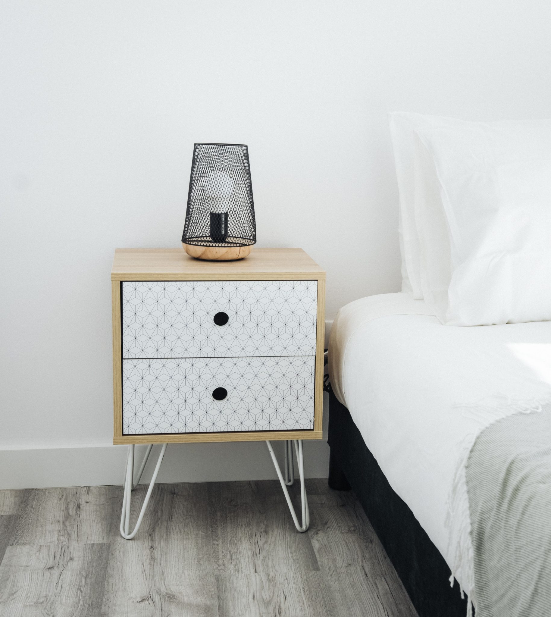 Stylish and modern bedroom featuring a minimalist nightstand with a decorative lamp.