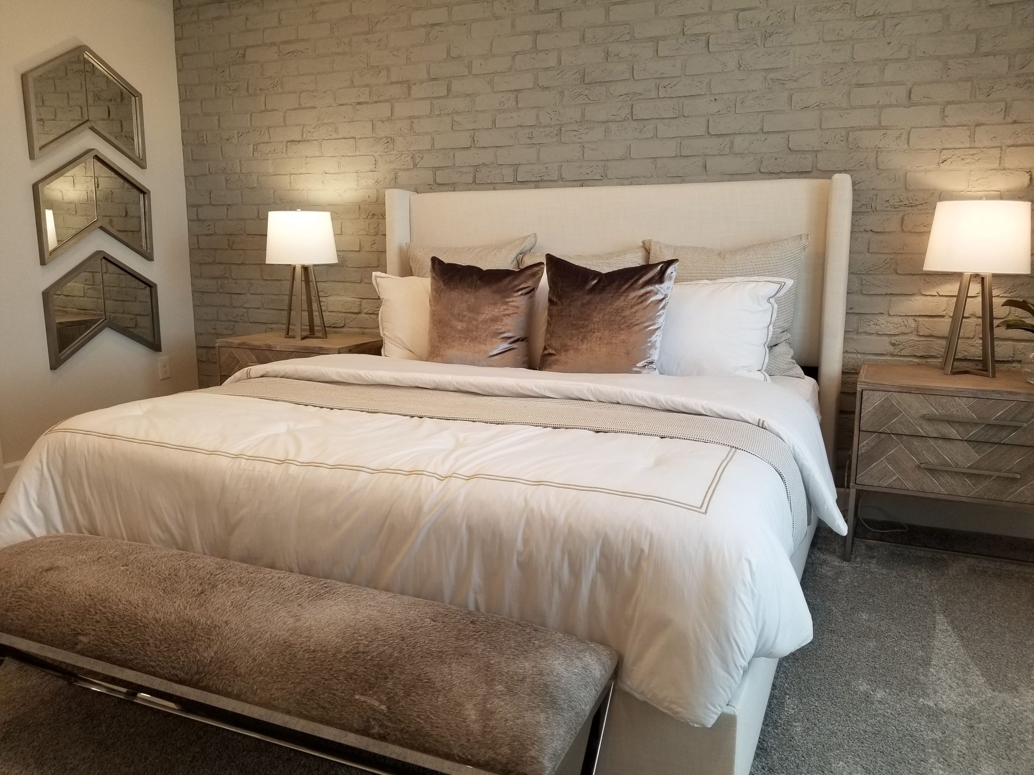 Stylish bedroom featuring a plush bed, decorative lamps, and contemporary decor.