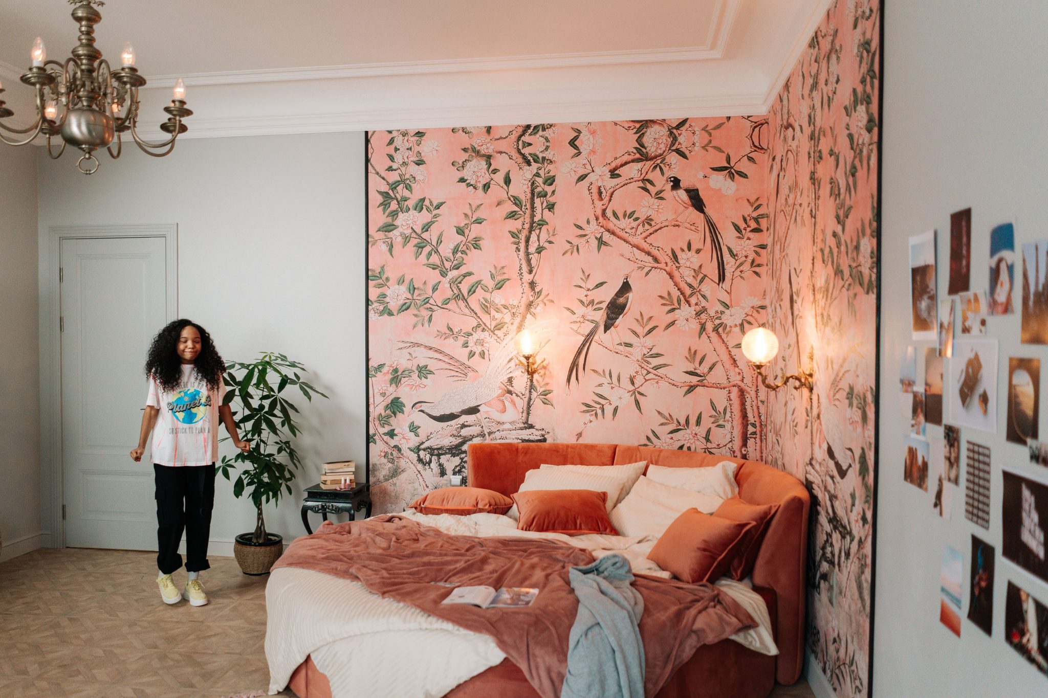 Stylish bedroom featuring a teenager, vibrant wallpaper, and eclectic decor.