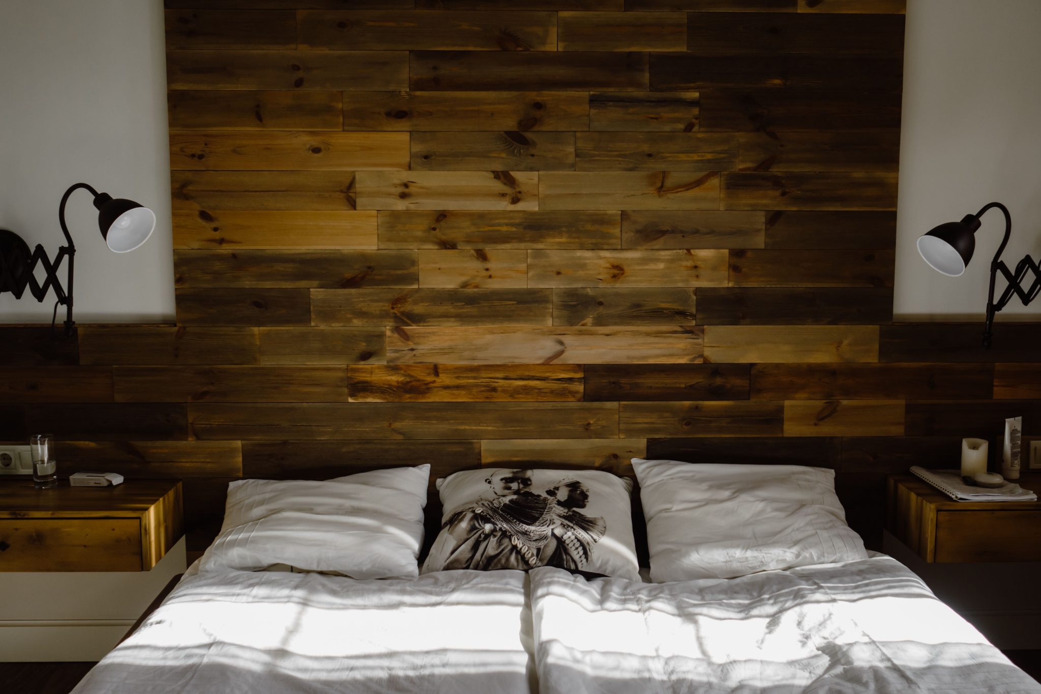 Stylish bedroom interior featuring a wooden headboard and ambient lighting.