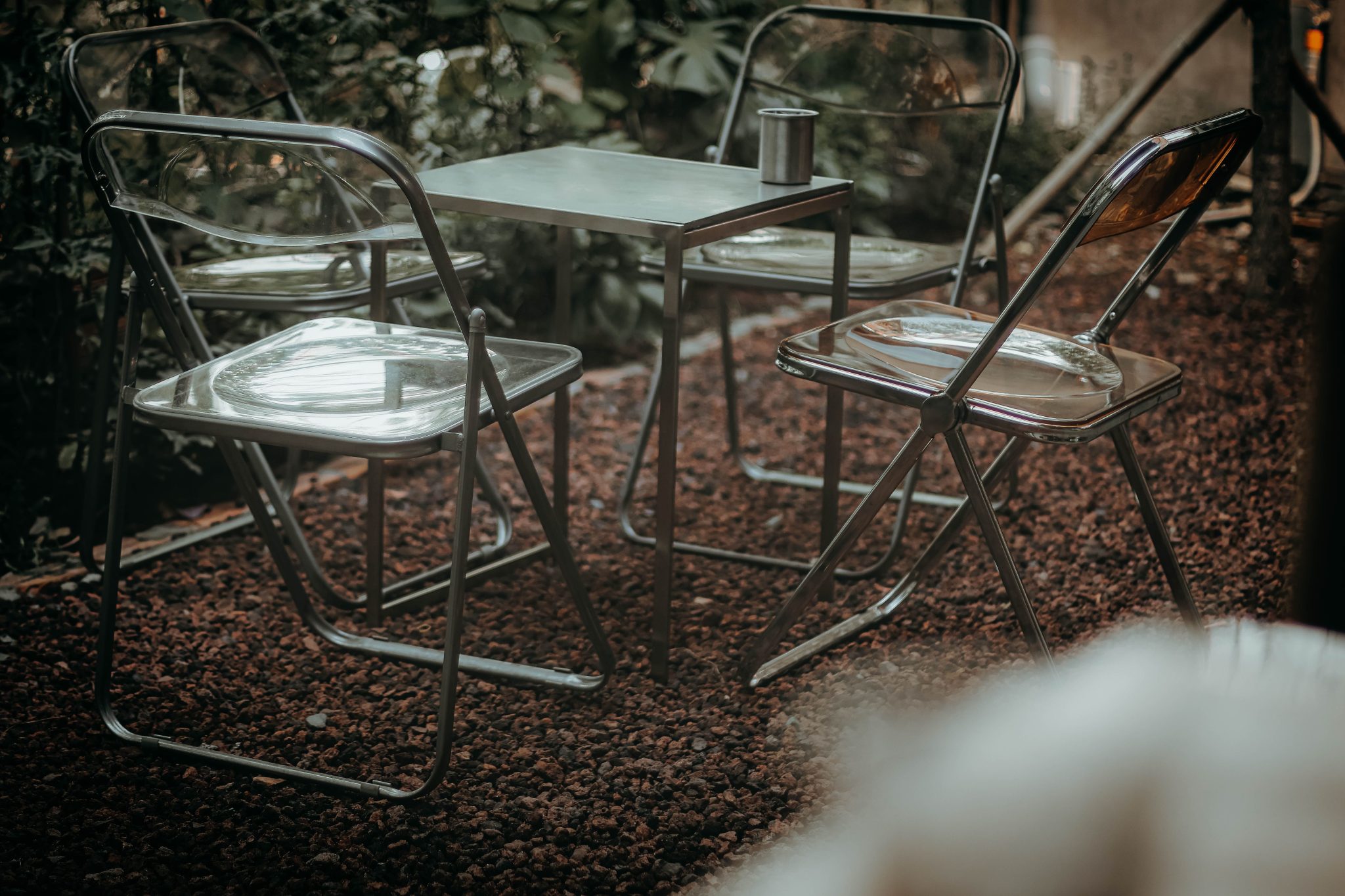 Stylish outdoor metal table and chairs set in a garden setting.