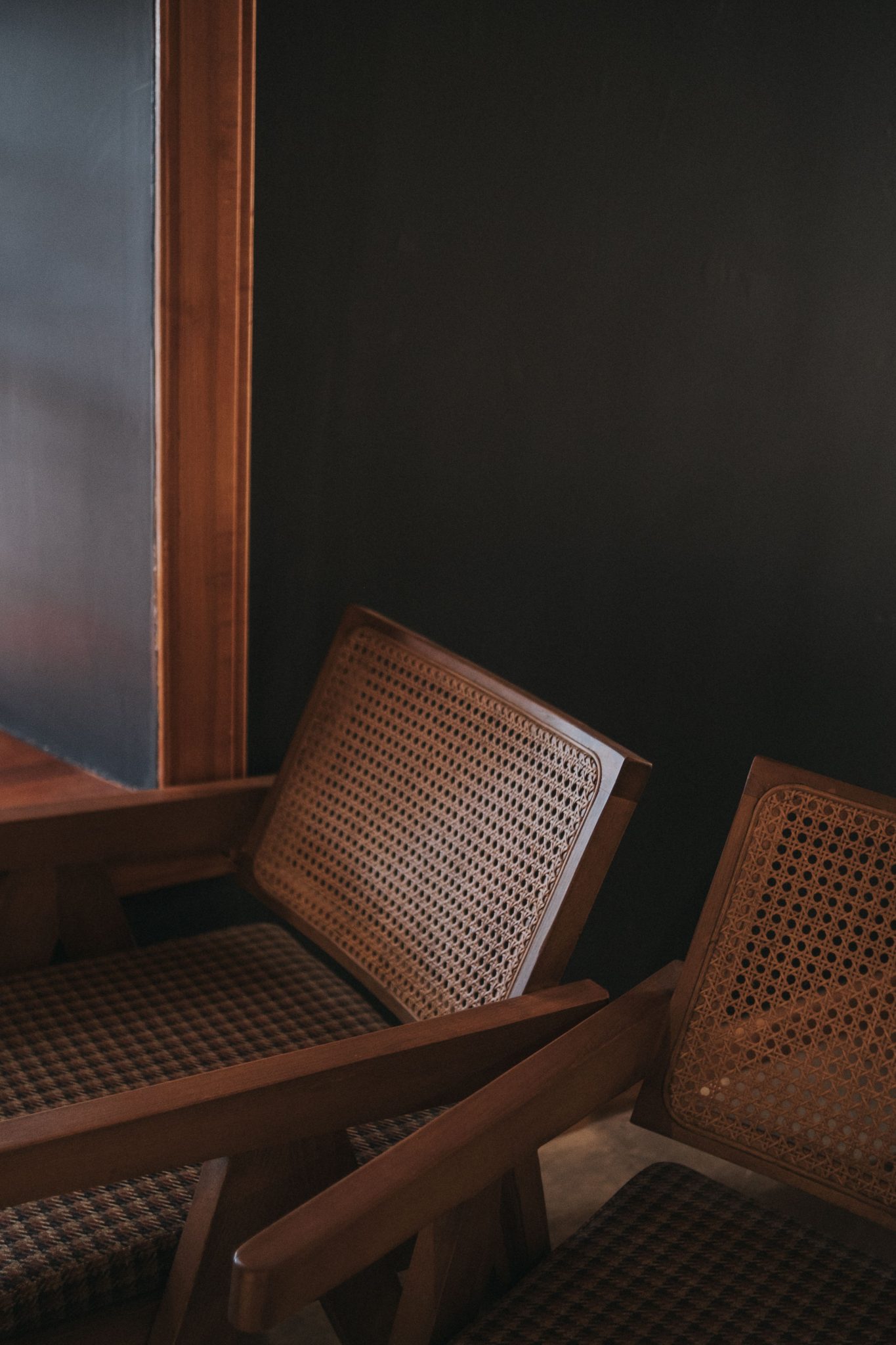 Stylish wooden armchairs with woven backs in a minimalist interior design setting.