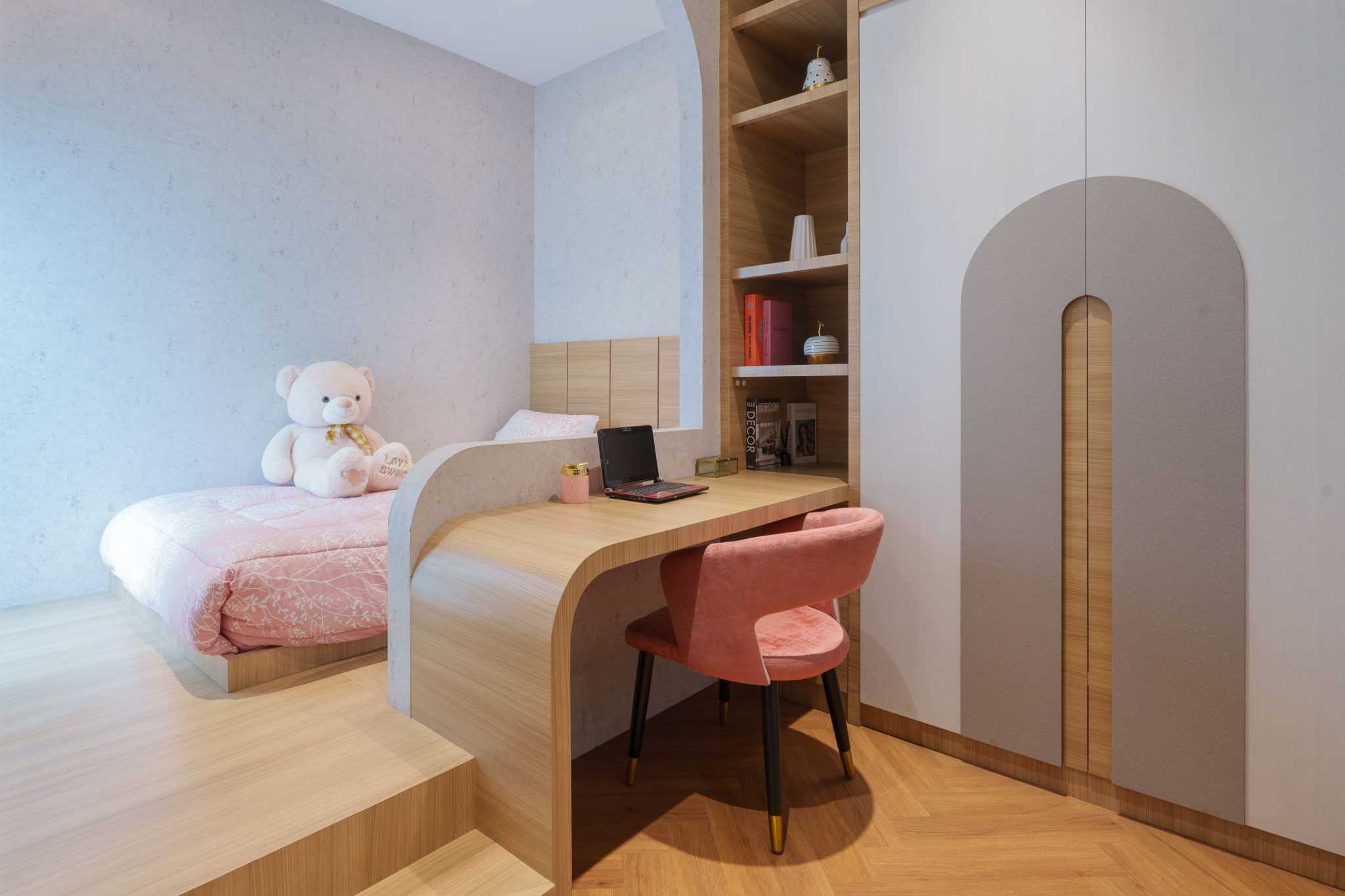 Warm and cozy children's bedroom with a desk and large teddy bear in Jakarta, Indonesia.