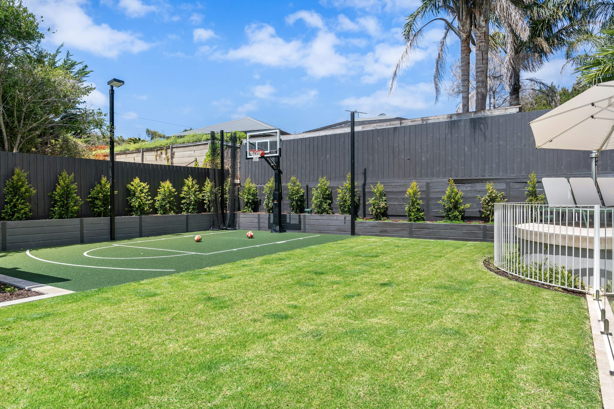 A backyard with a basketball court and a fence photo – Free Football Image on Unsplash