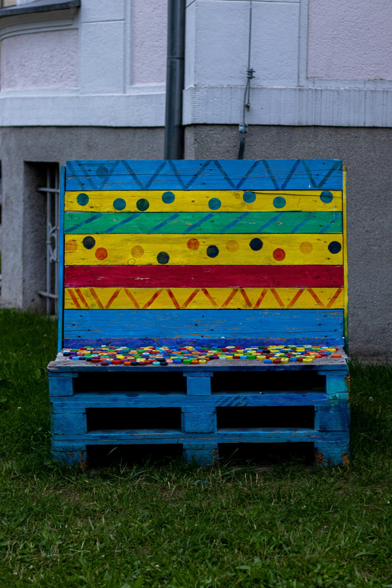 A bench made out of pallets sitting in the grass