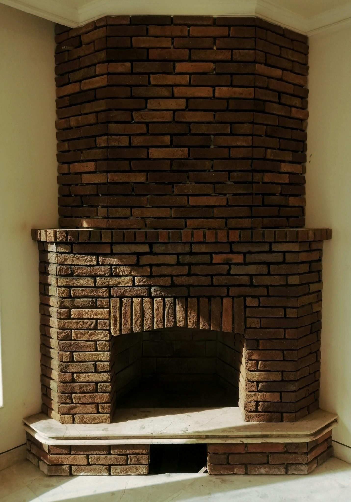 a brick fireplace in a corner of a room