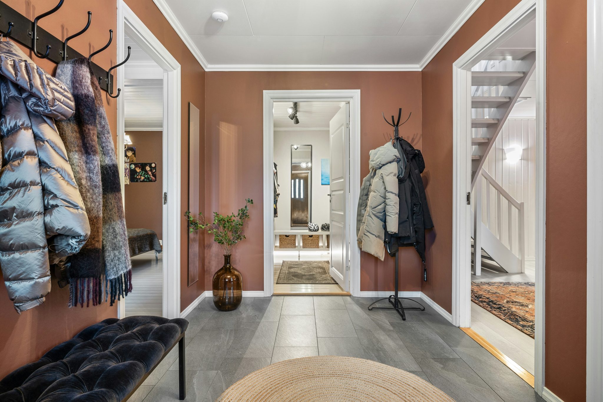 A hallway with a coat rack and a bench