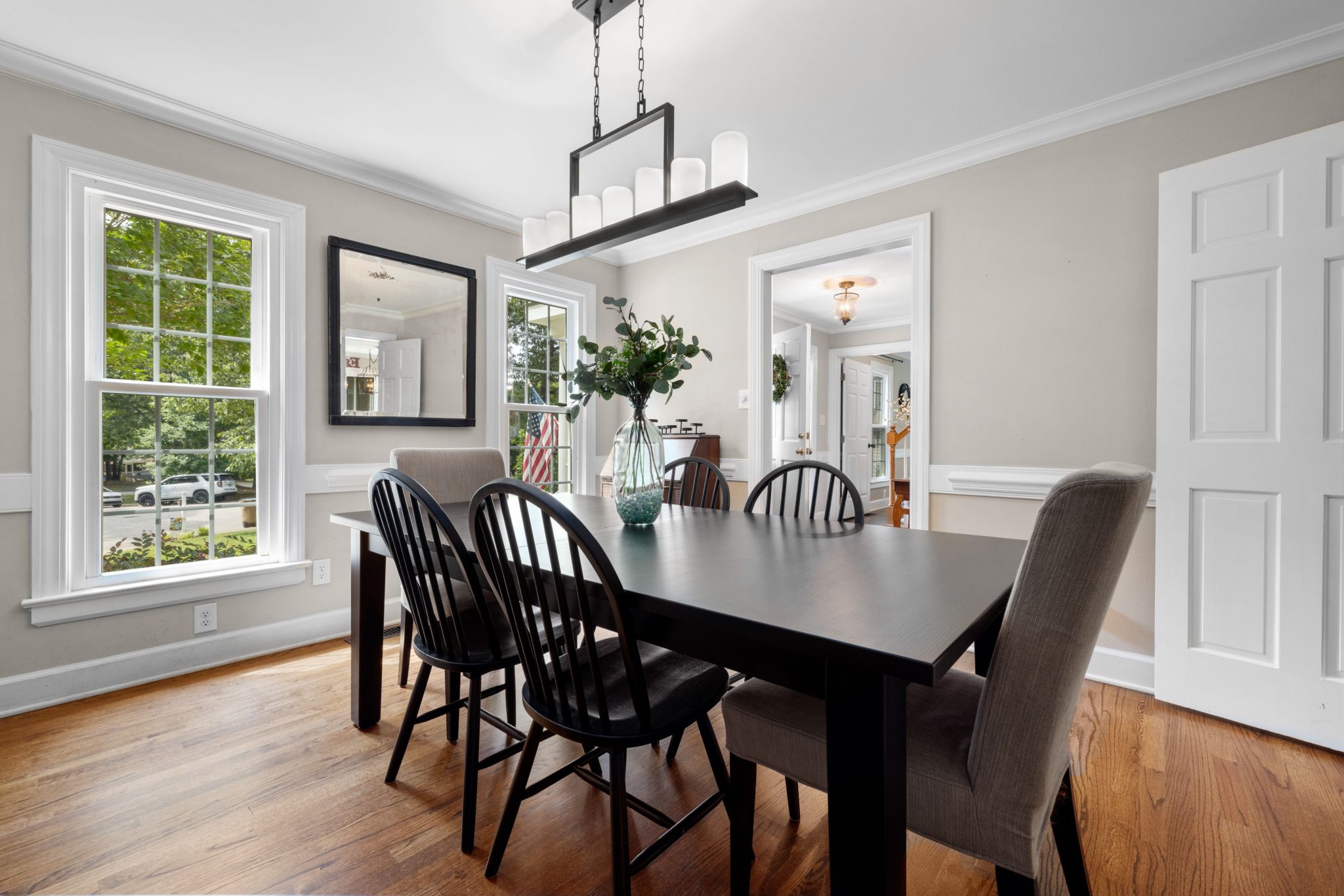 A modern and elegant dining room with a black table and chairs under natural light.
