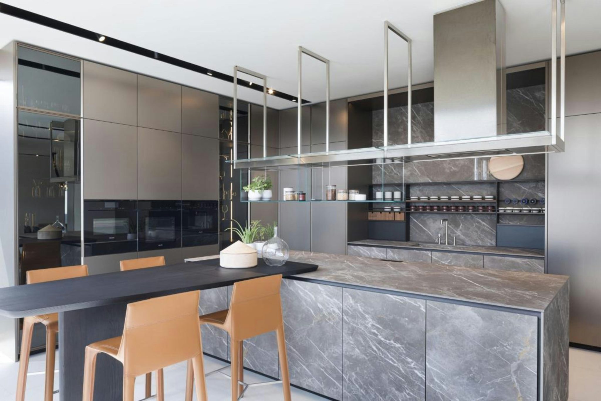 A sleek and modern kitchen featuring high-end Poliform cabinetry and a luxurious marble countertop. The design combines minimalist elements with functional beauty, highlighted by the elegant hanging r
