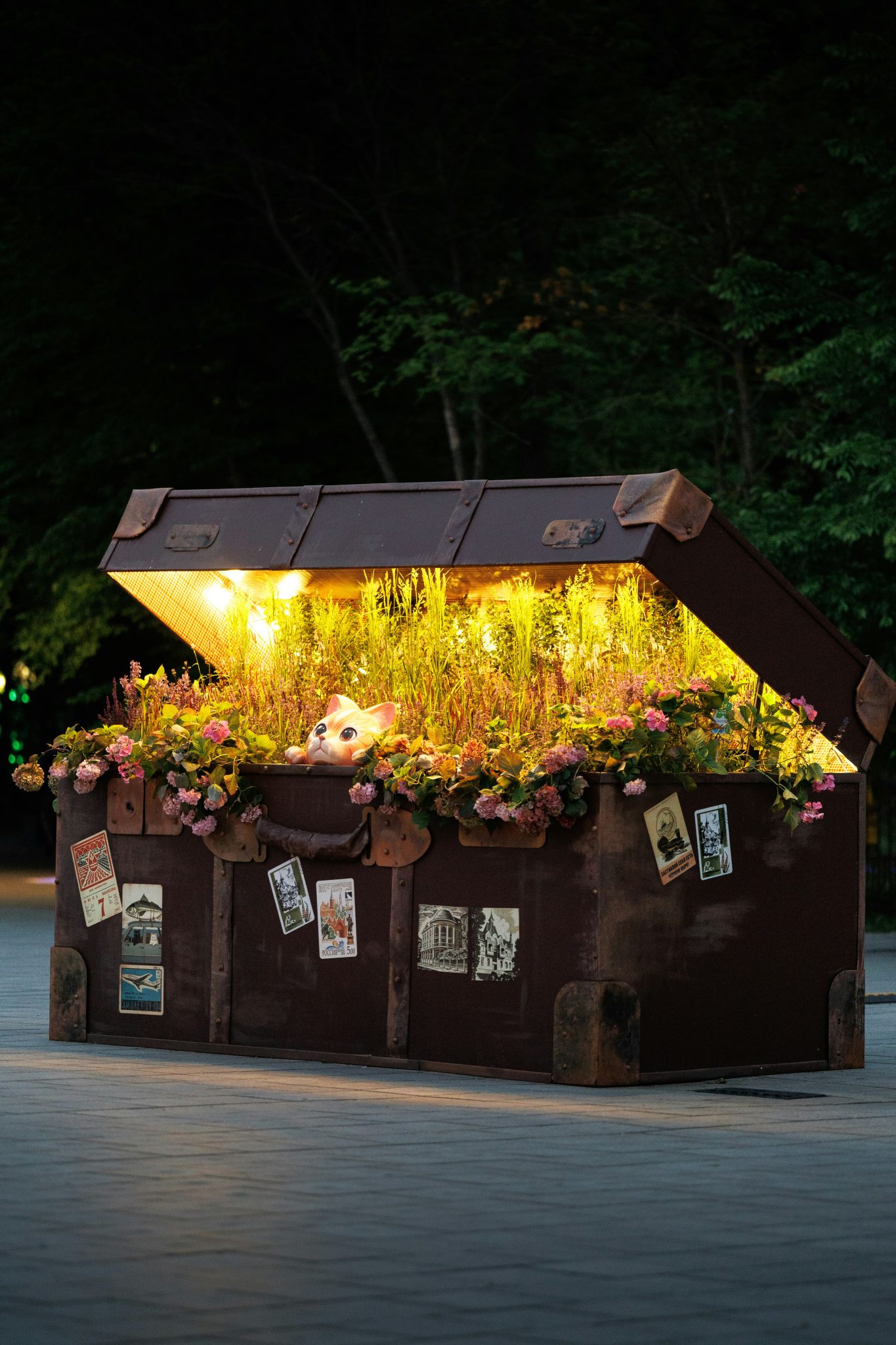 An old suitcase filled with flowers and lights at night.