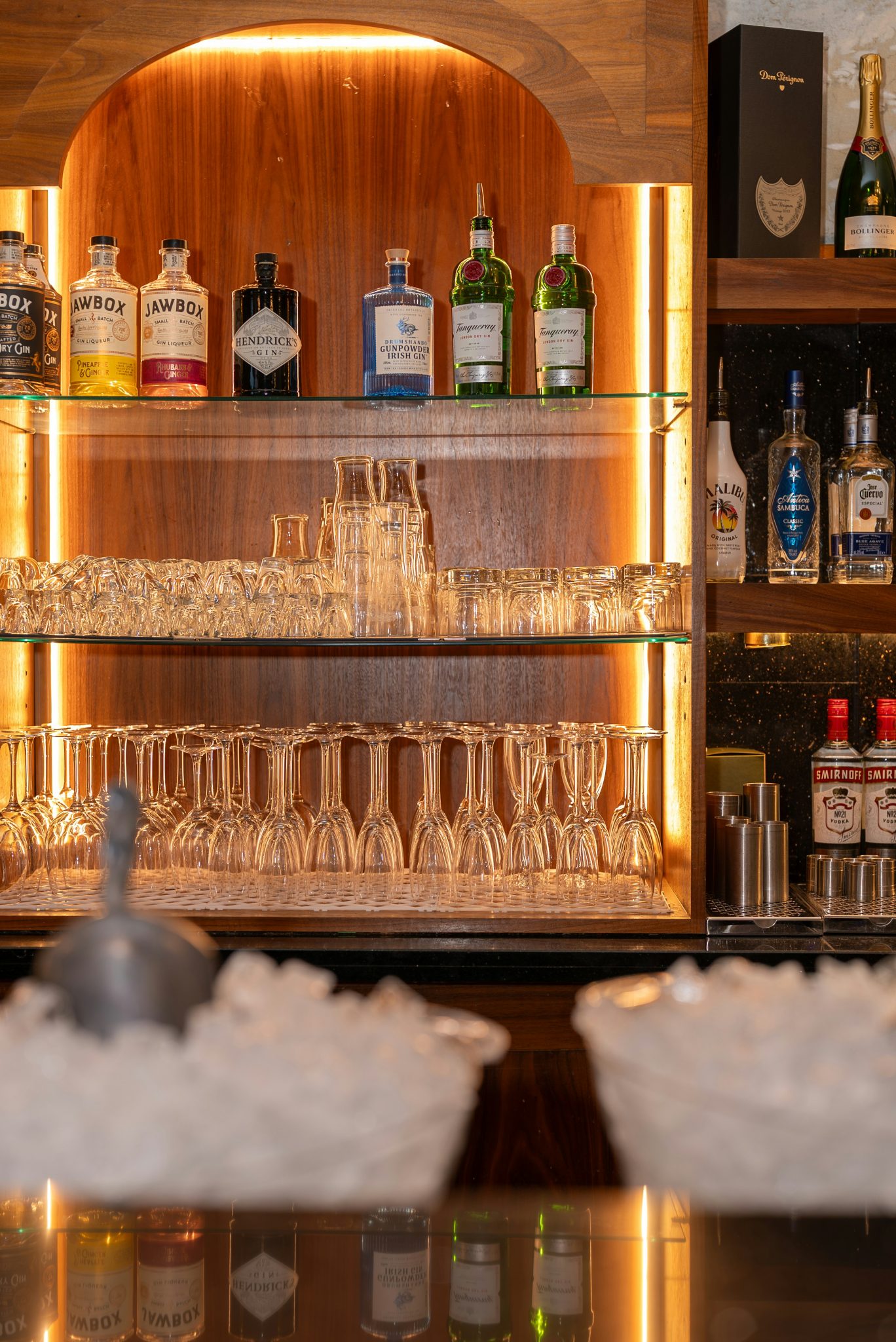 Bottles of liquor and glassware on bar shelves
