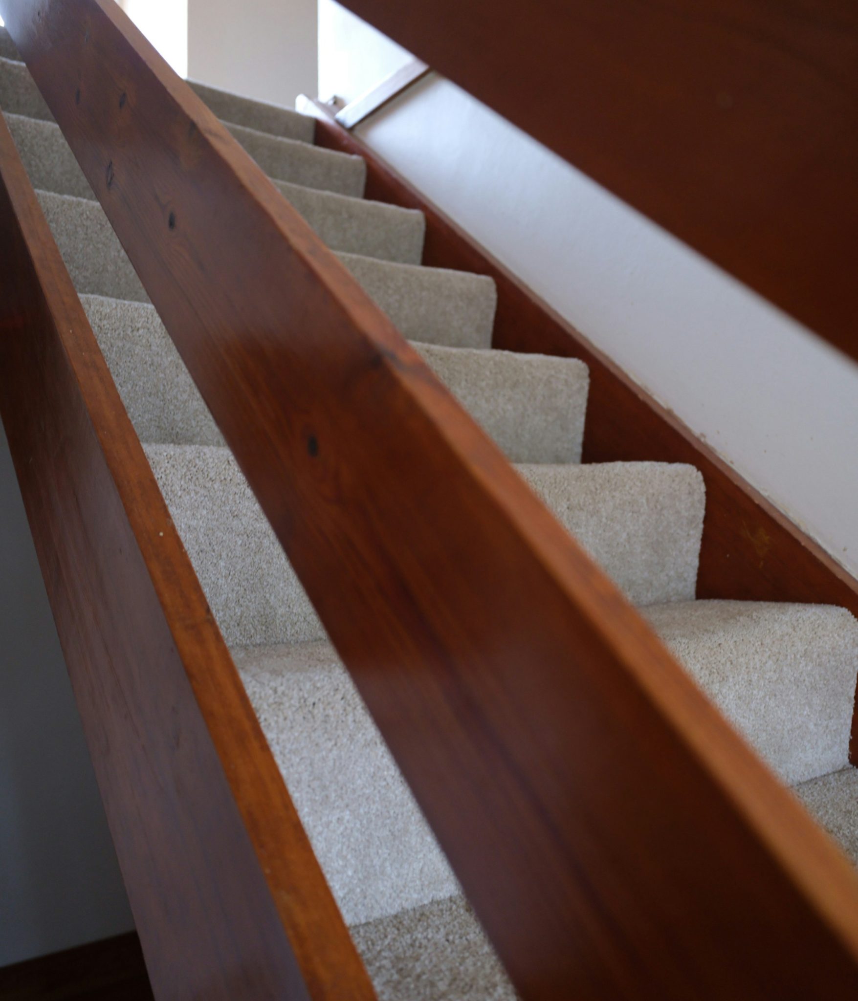 Carpeted stairs with wooden banister and railing.
