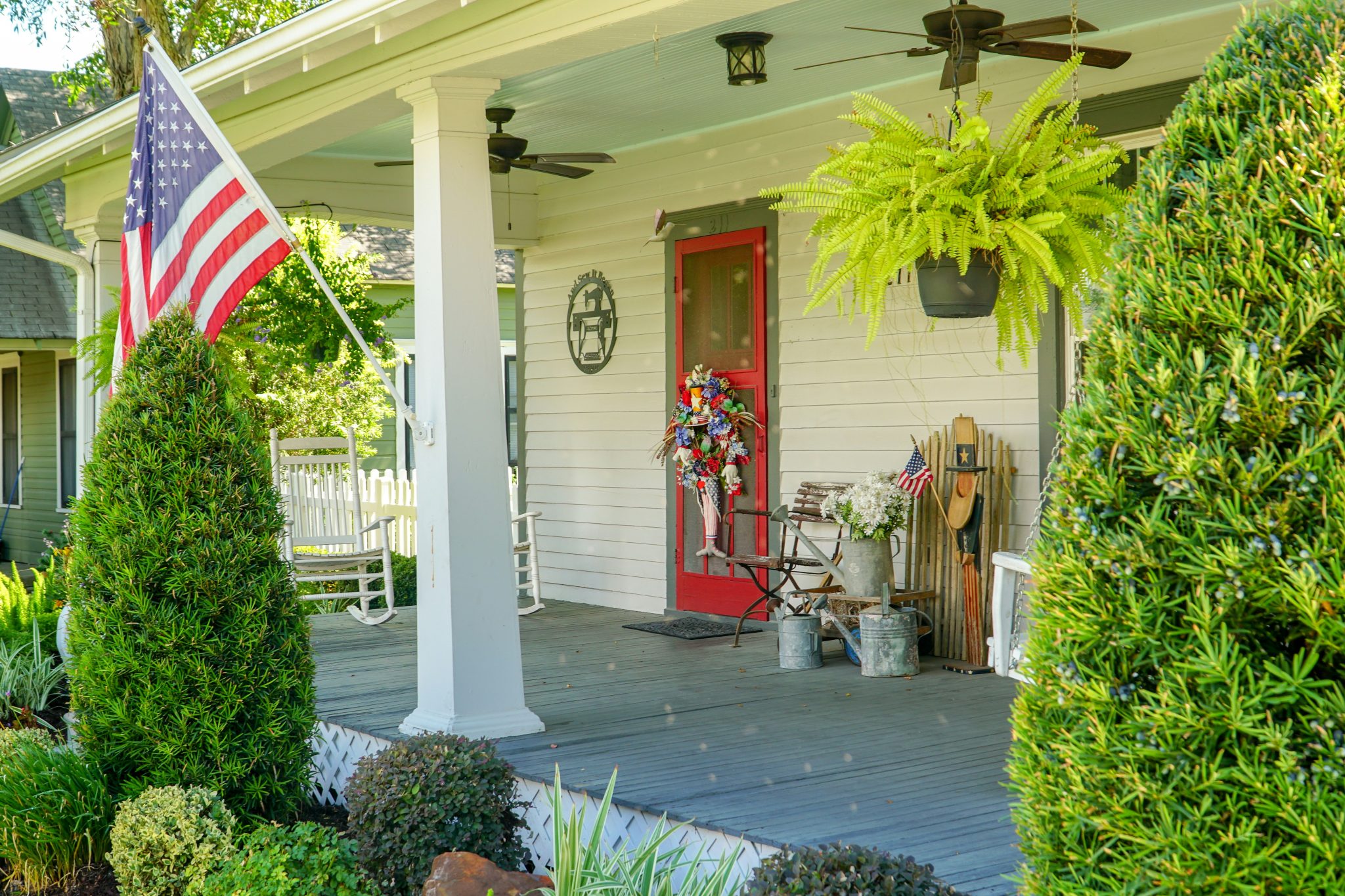Classic southern American farmhouse front porch decorated for a summer 4th of July celebration.