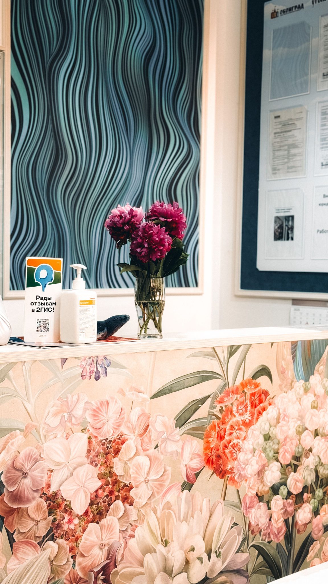 Colorful floral decor at a reception desk with modern wall art, creating a welcoming ambiance.