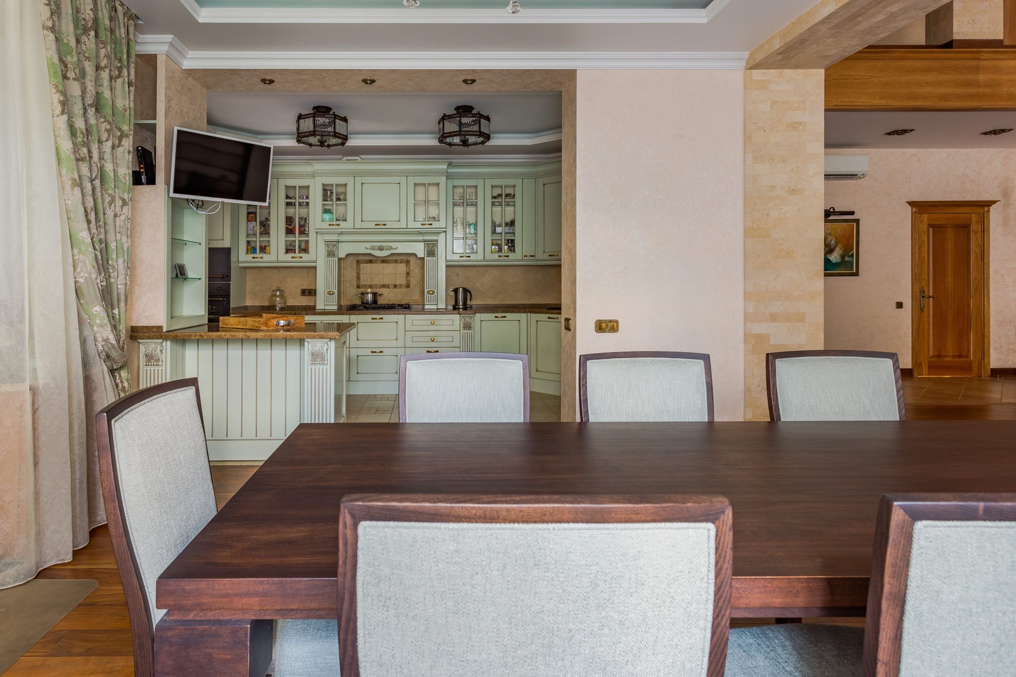 Cozy dining area with wooden table and modern kitchen in background, ideal for interior design inspiration.