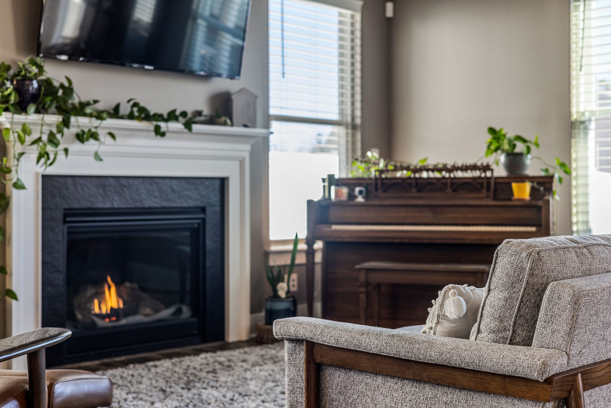 Elegant living room featuring a fireplace and piano, perfect for a relaxing evening indoors.