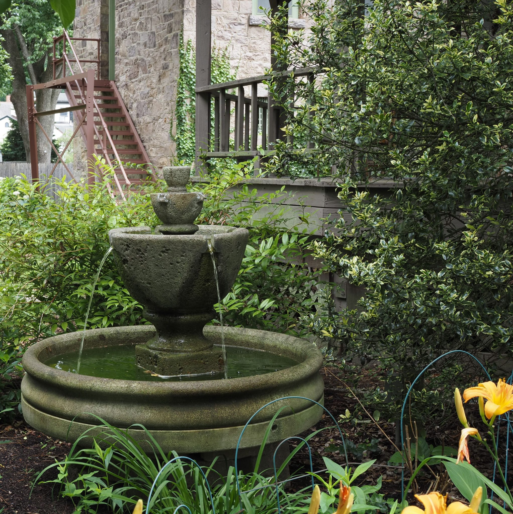 Elegant stone fountain surrounded by lush greenery in Lambertville, New Jersey garden.