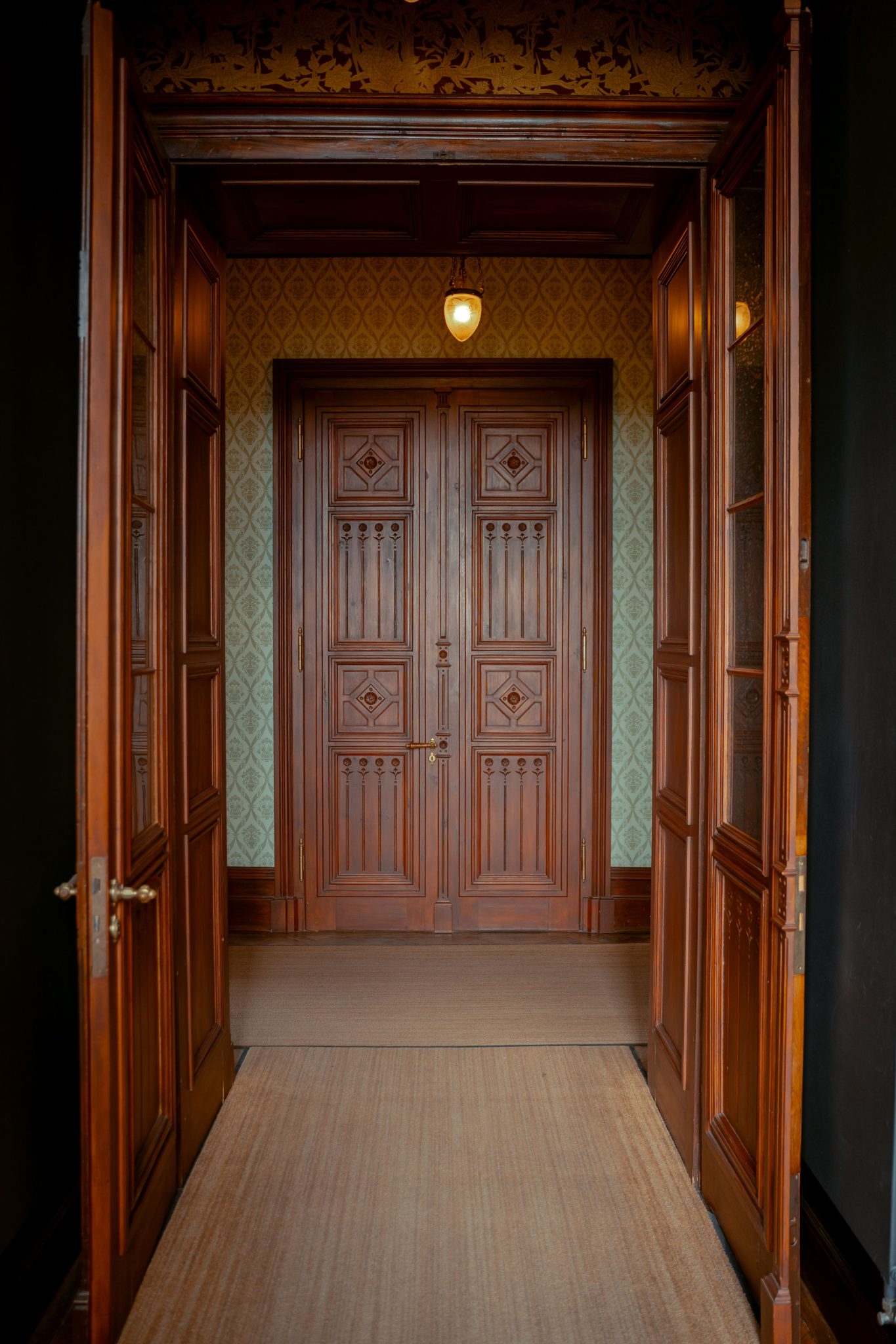 Elegant wooden corridor with vintage double doors and intricate design in Germany.