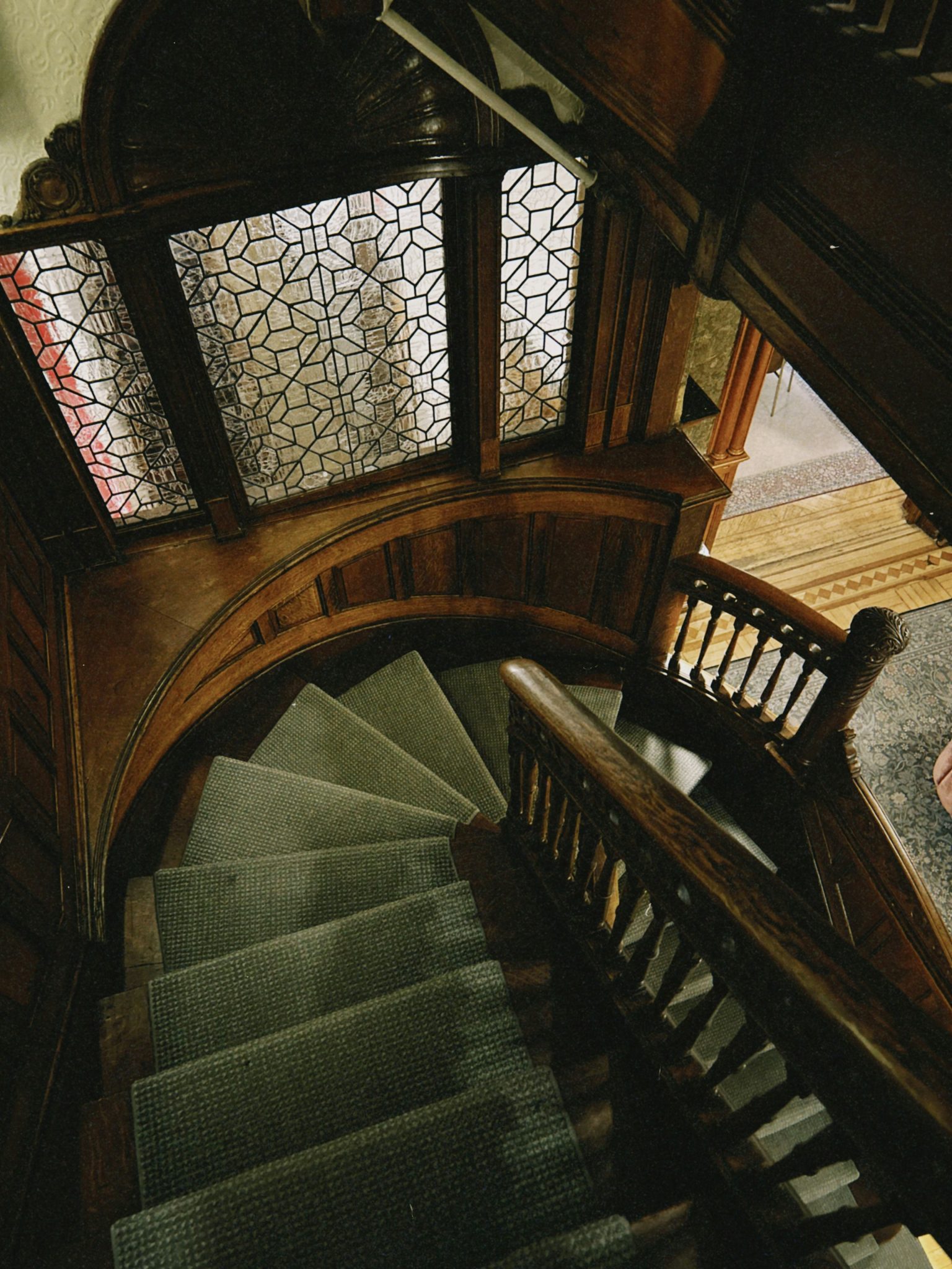 Elegant wooden staircase with patterned window above