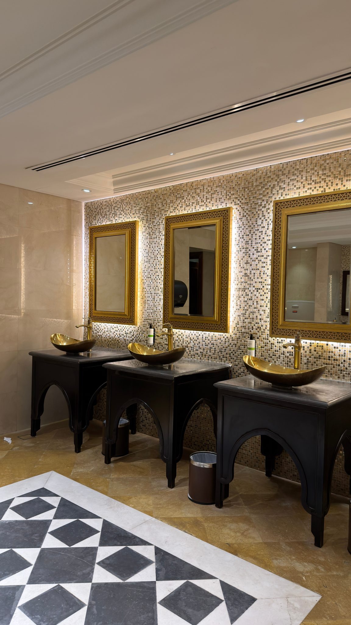 Luxurious bathroom interior with gold framed mirrors and designer sinks