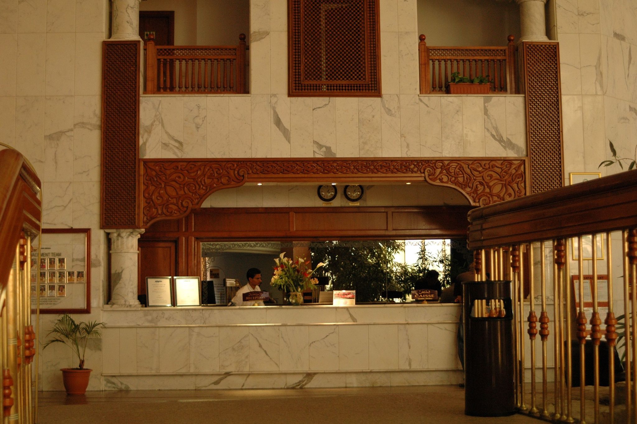 Luxurious hotel reception area with marble walls and detailed woodwork design.