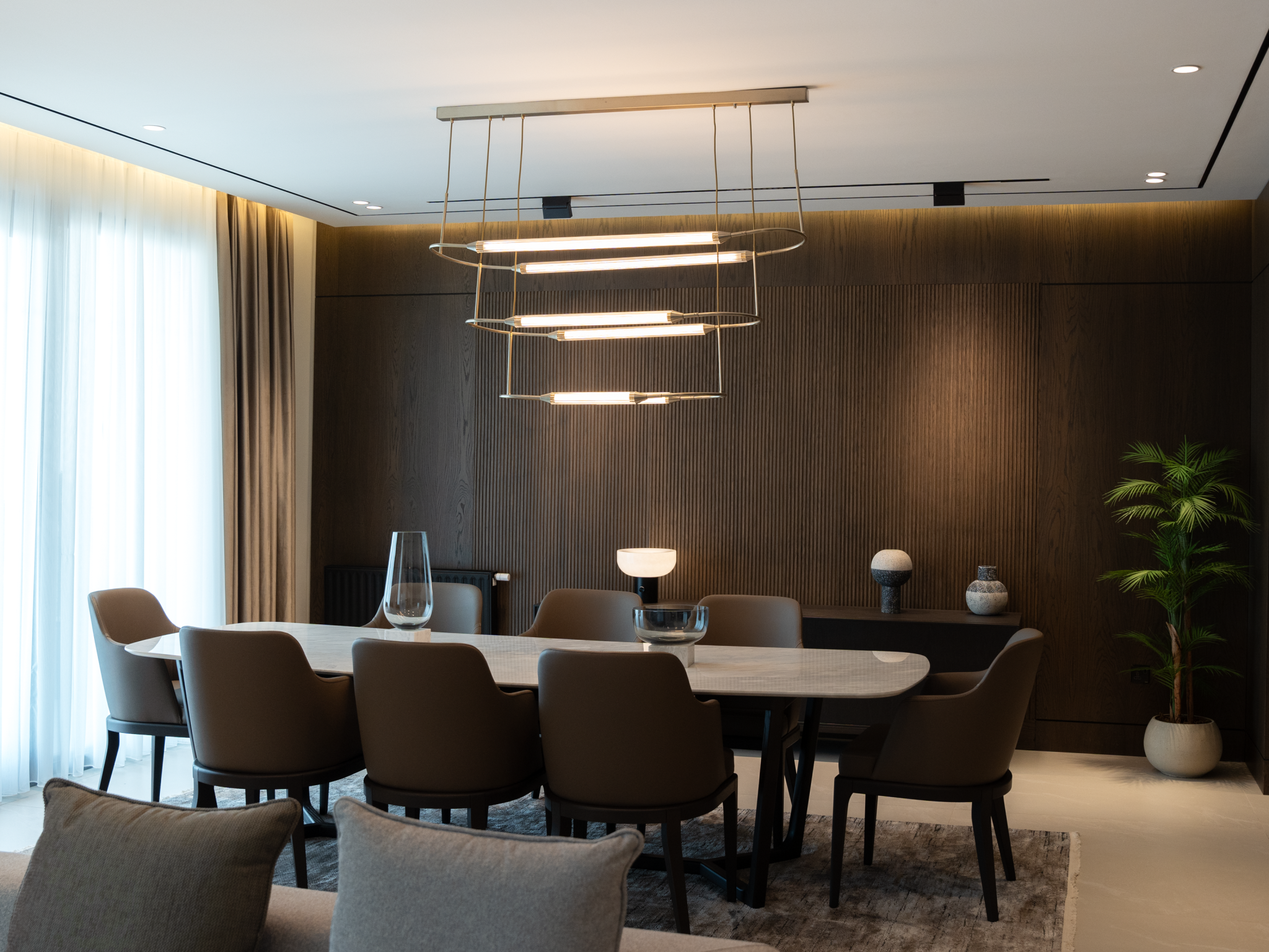 Luxurious modern dining room featuring chic chandelier and elegant furnishings creates a sophisticated ambiance.