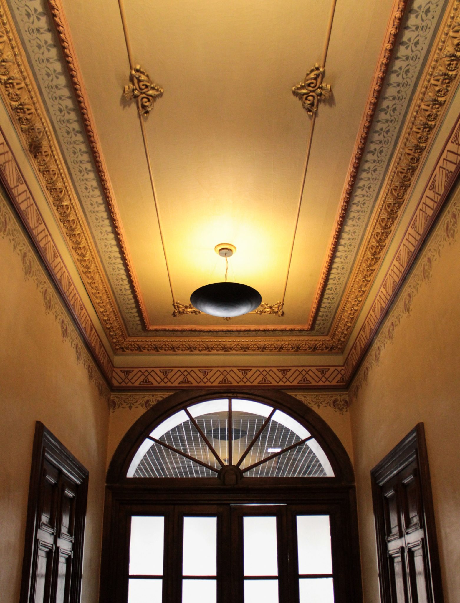 Luxurious vintage hallway with intricate ceiling design and wood details.