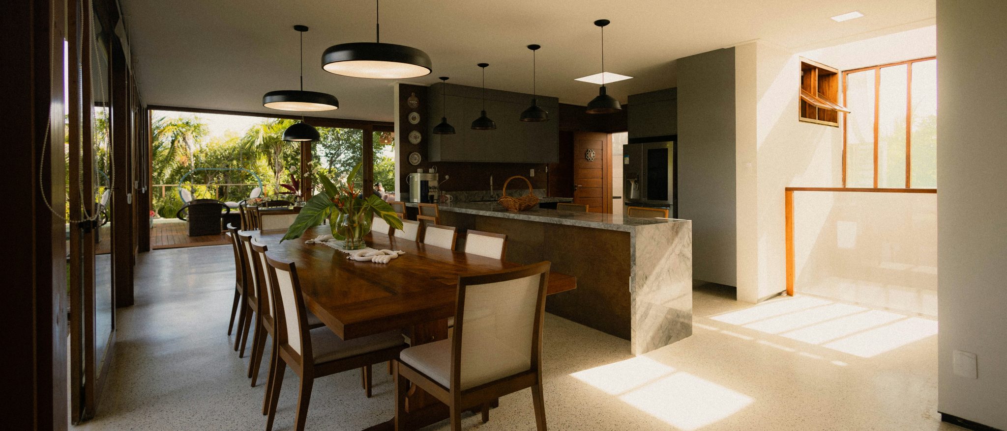 Modern dining room and kitchen with large windows.