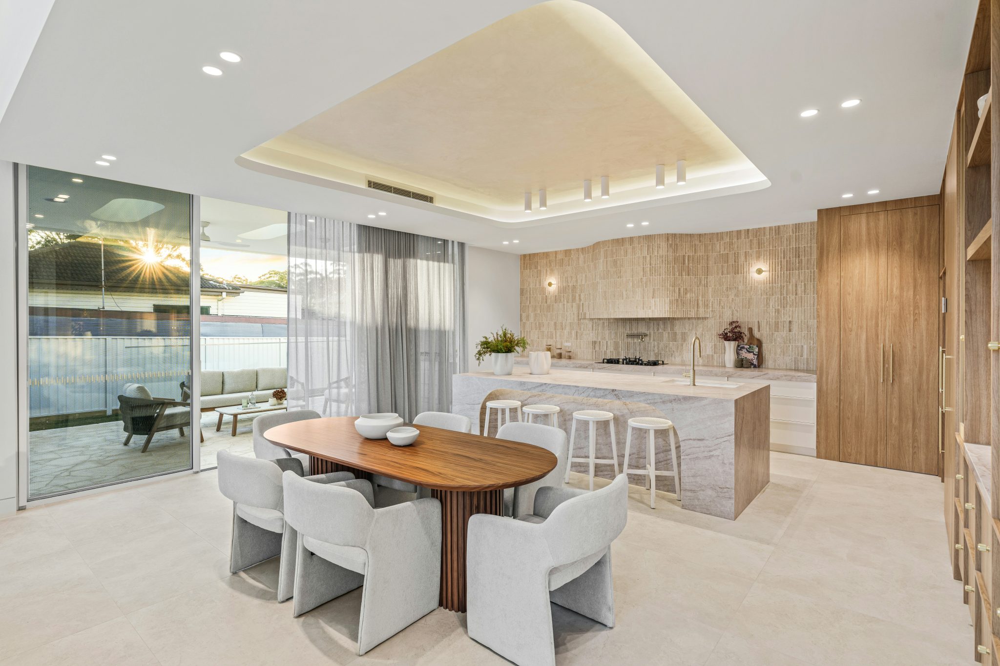 Modern open-plan kitchen and dining area with outdoor patio.