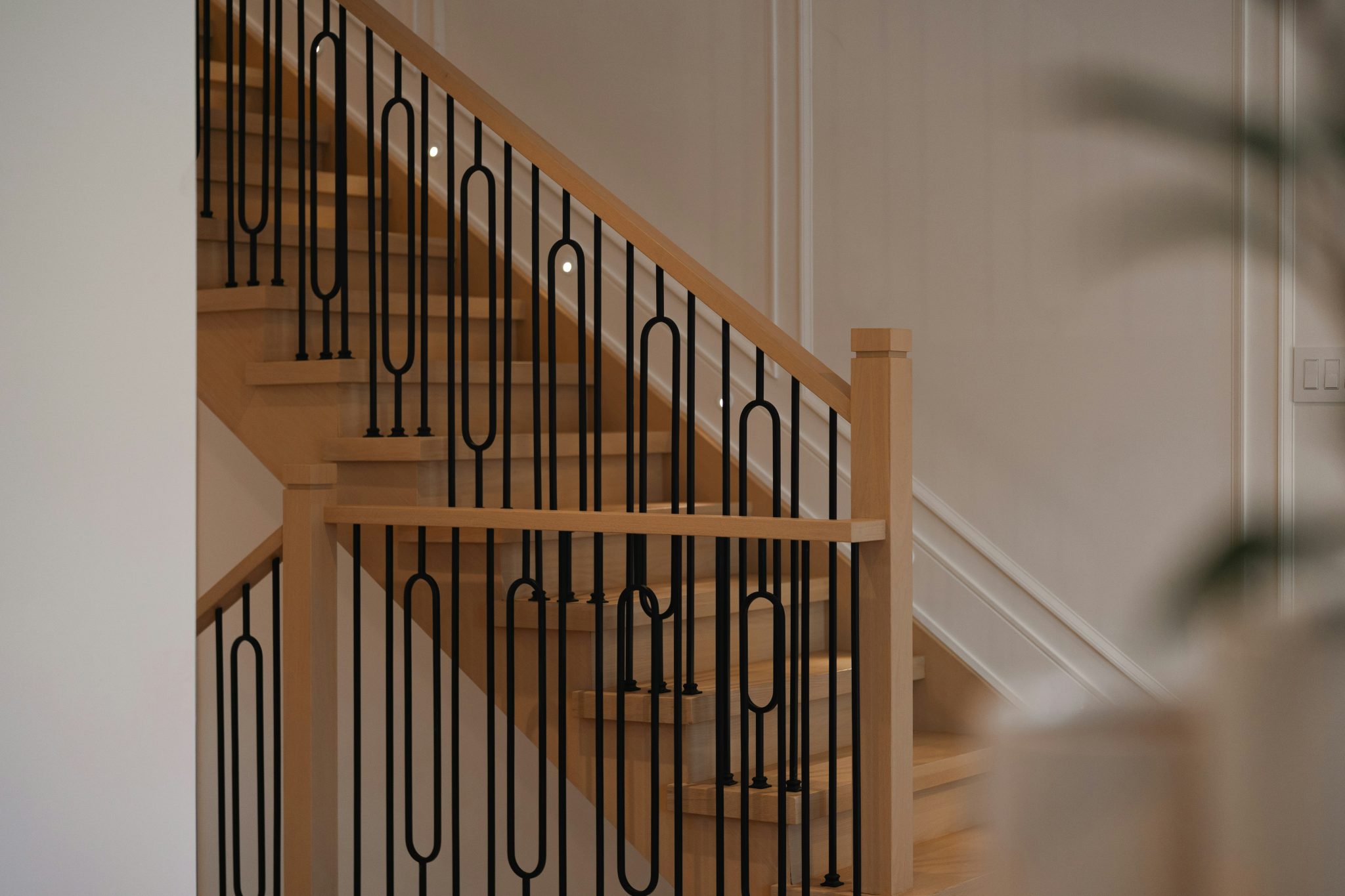 Modern wooden staircase with black metal railing
