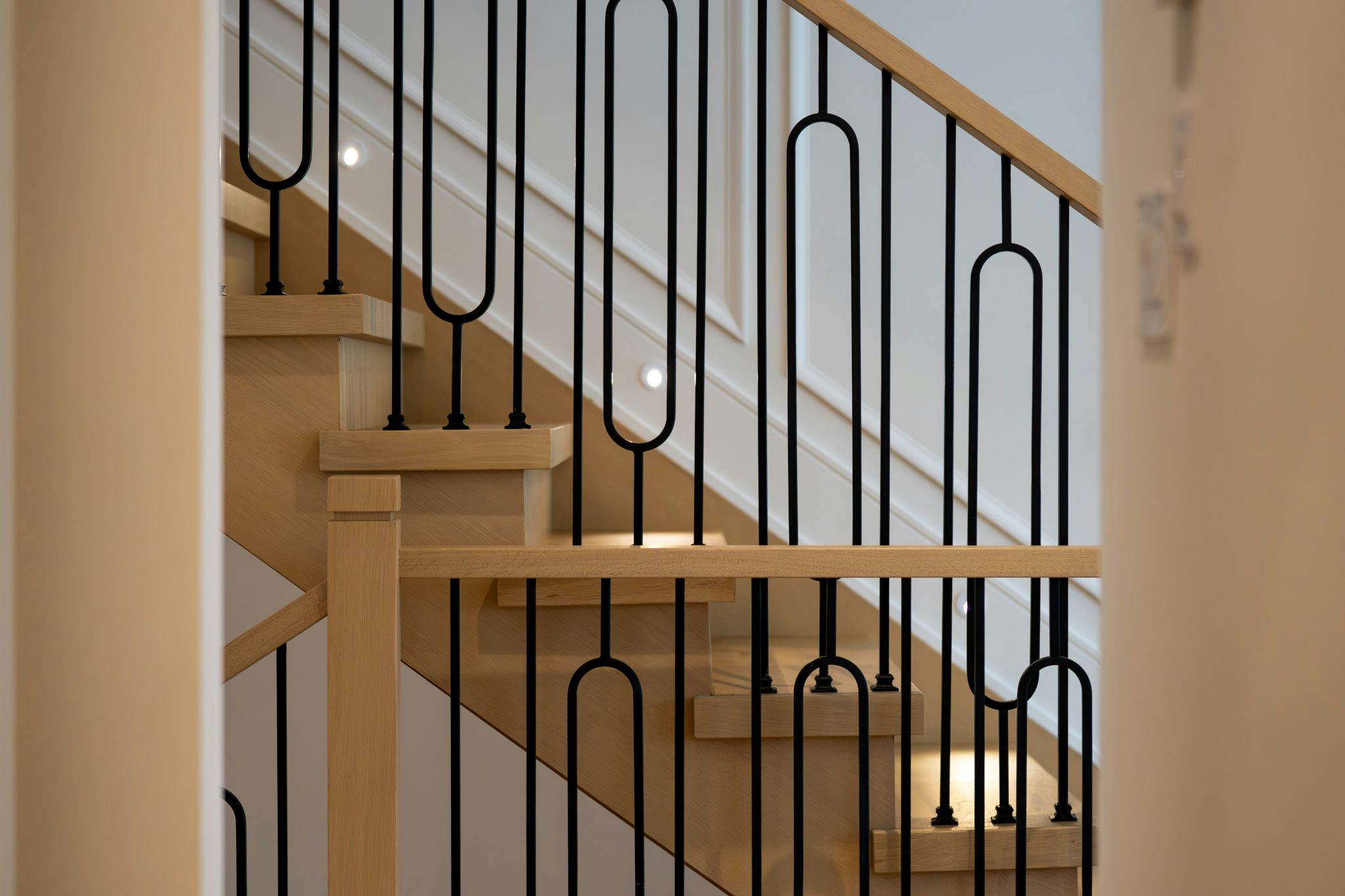 Modern wooden staircase with black metal railing