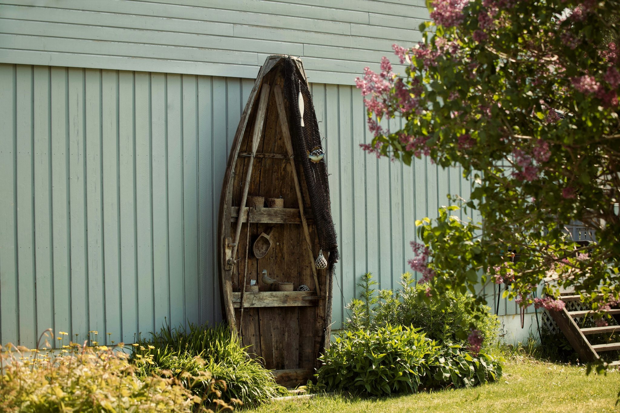 Old rowboat used as outdoor decoration in a blooming garden