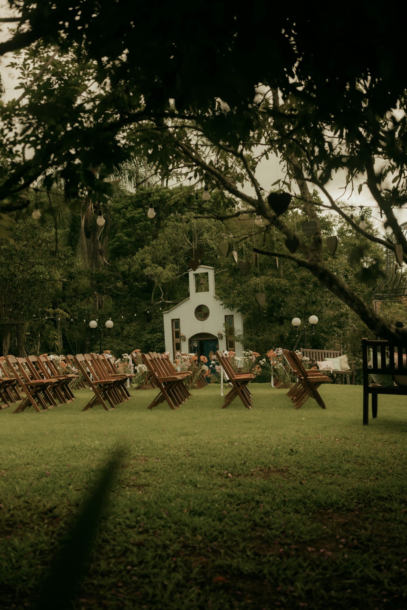 Outdoor wedding ceremony setup with chairs and small chapel.
