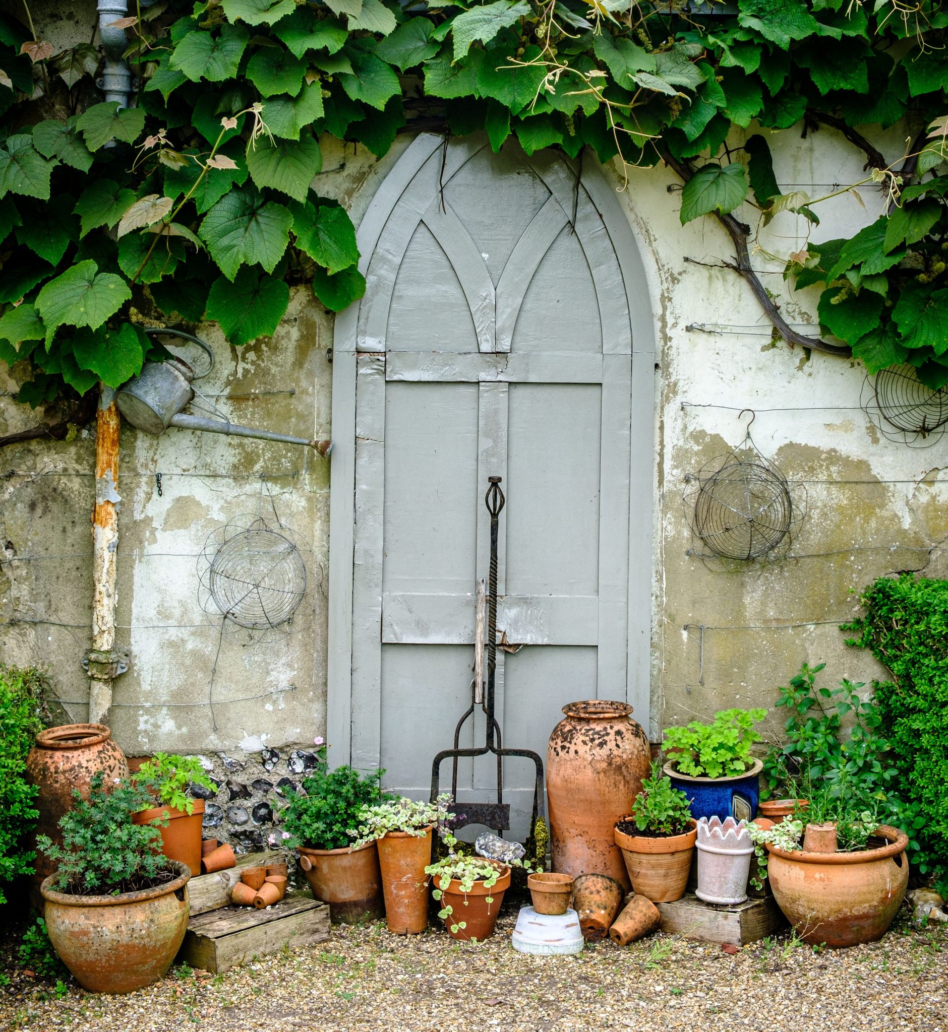 Rustic garden door framed by pots in North Houghton, England, exuding rustic charm.