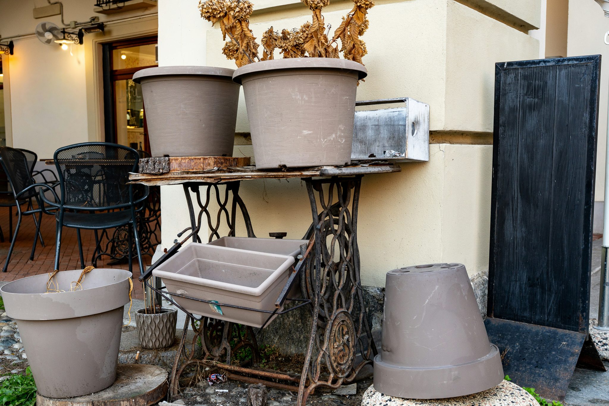 Several empty planters on an antique sewing machine base.