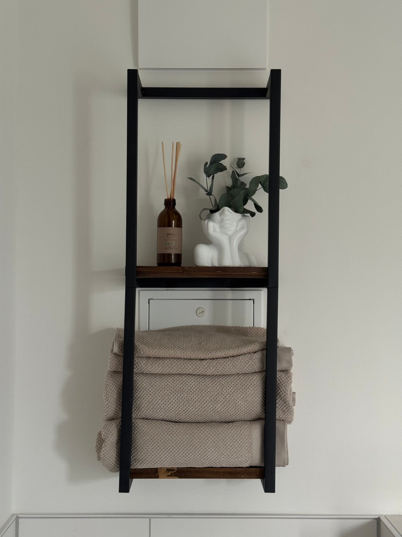 Stylish bathroom shelf in Berlin featuring modern decor and towels.