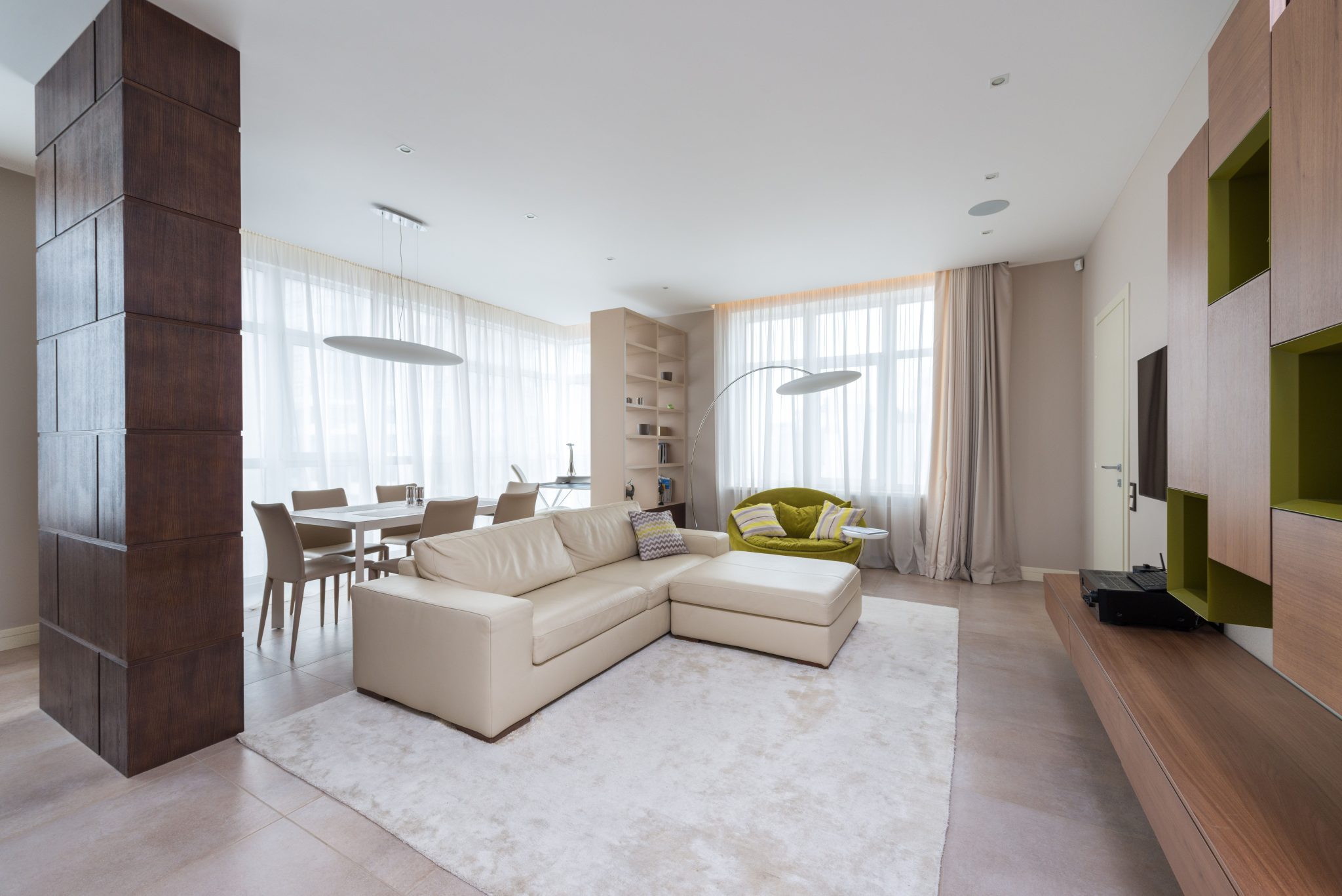 Stylish interior of spacious living room with comfortable sofa in contemporary apartment in daytime