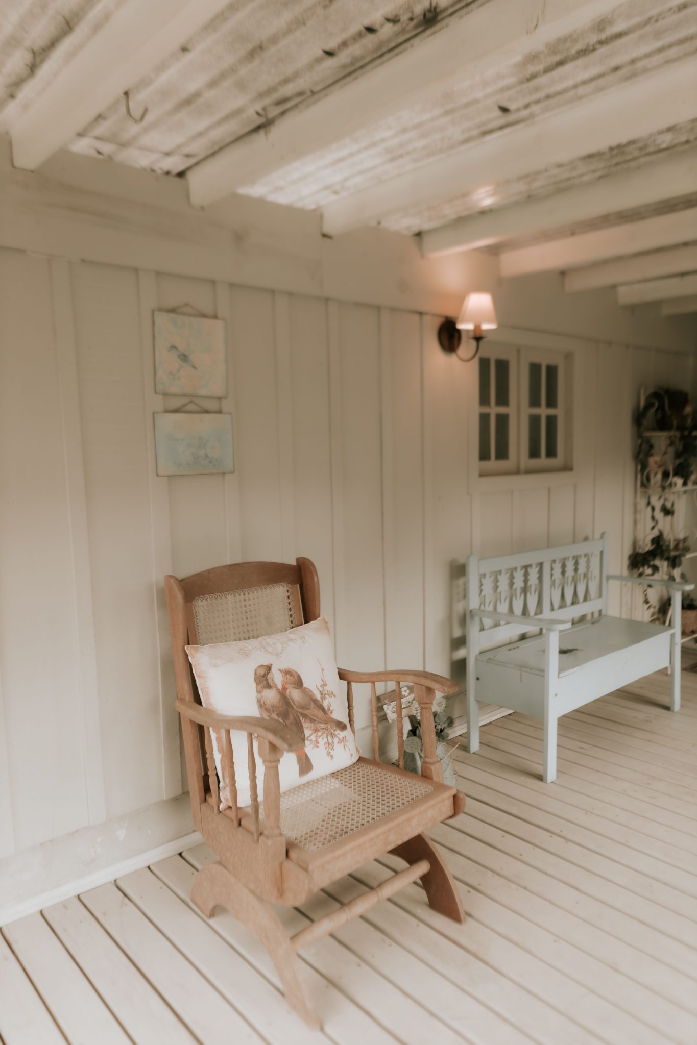 Warm and inviting porch featuring a wooden rocking chair and rustic bench.