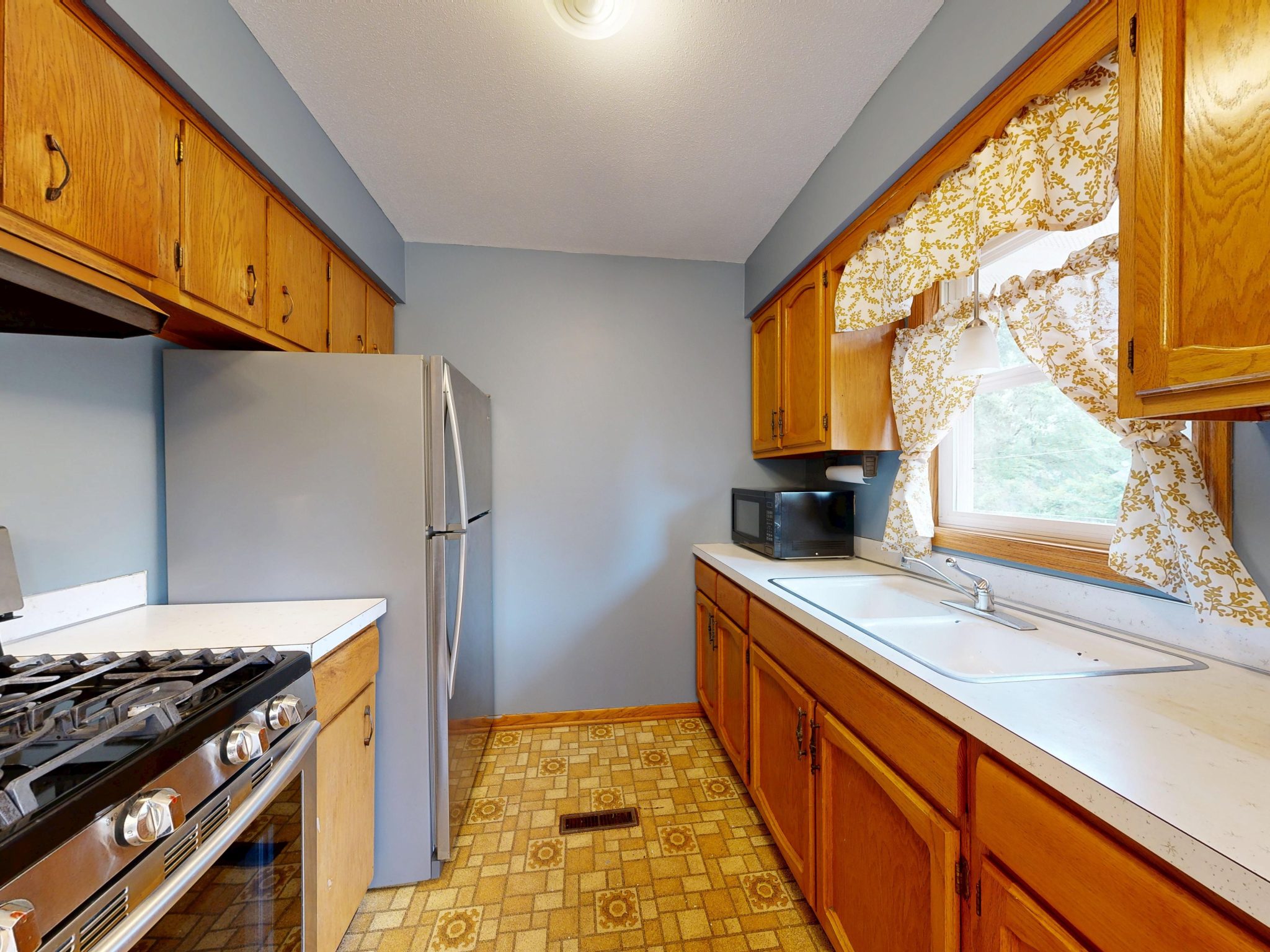 Warm, vintage-inspired kitchen with wooden cabinets and tiled floor, perfect for home cooking enthusiasts.