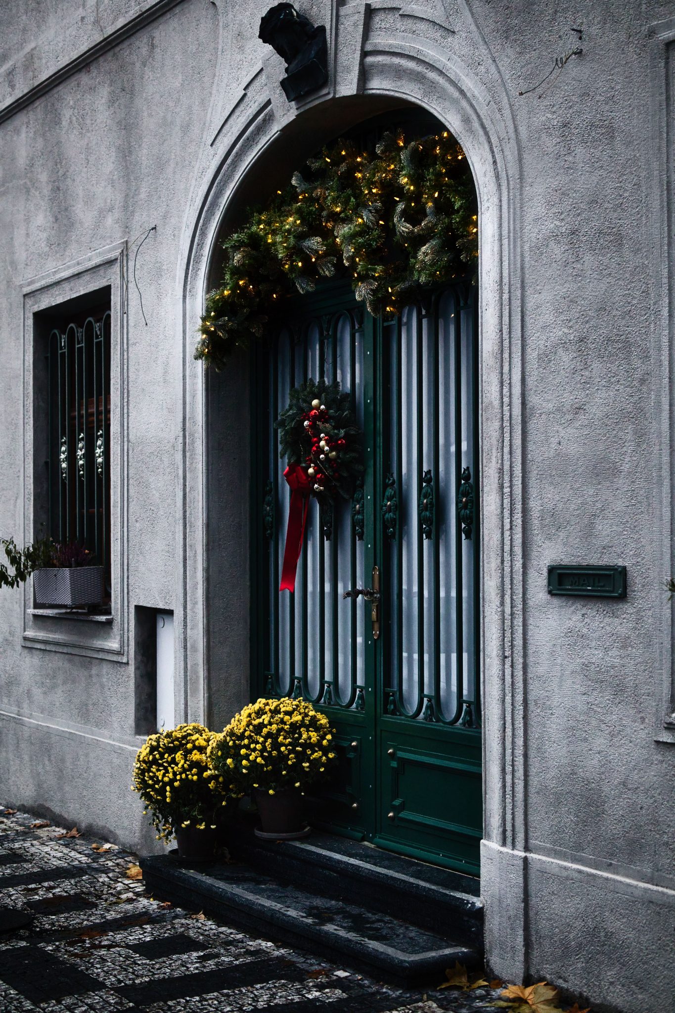 A beautifully decorated door with festive wreath, lights, and flowers, perfect for holiday inspiration.