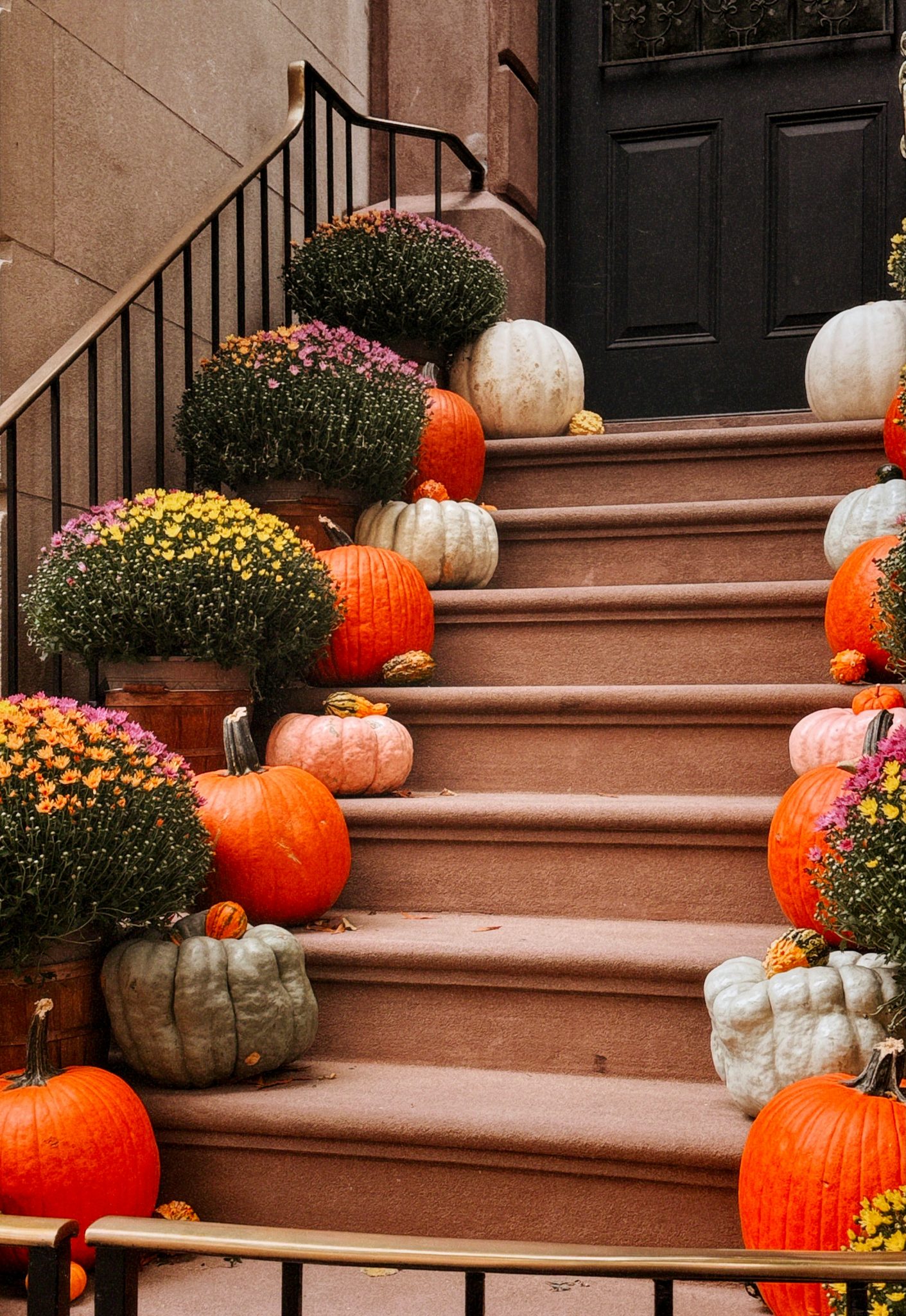 A bunch of pumpkins sitting on the steps of a house